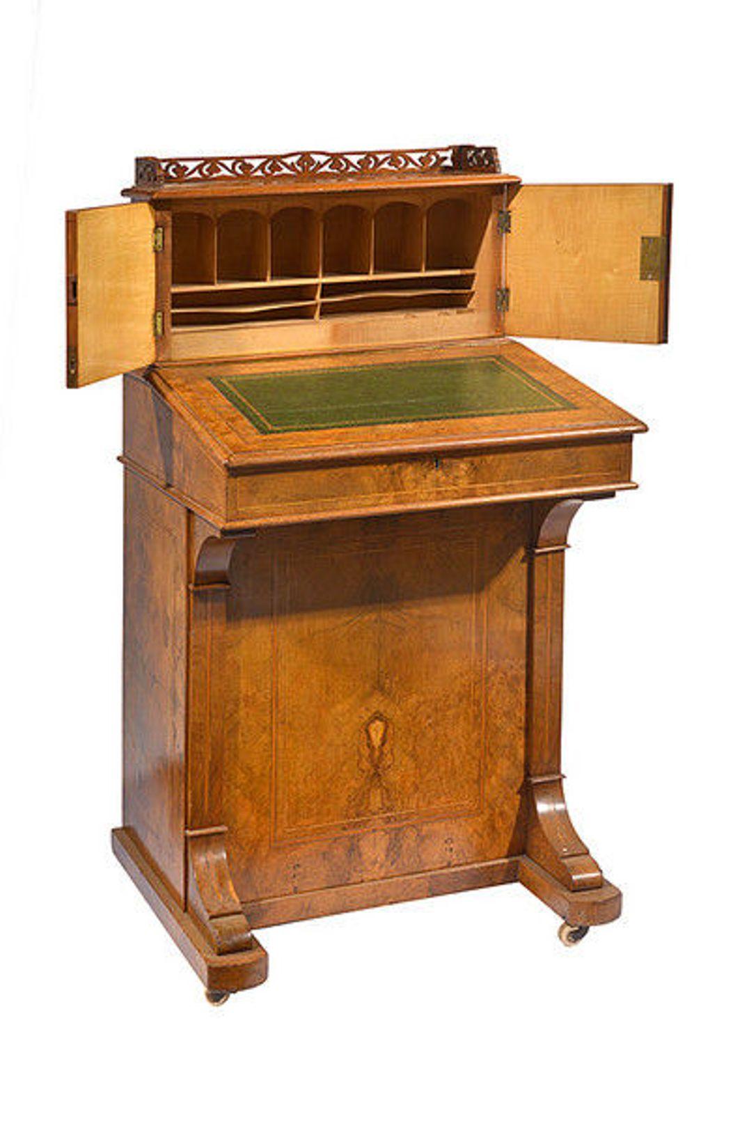 A mid-19th century figured walnut and satinwood marquetry davenport.
To the top, a pierced gallery above a pair of cabinet doors which open to reveal a maple lined interior with cubby holes an shelves
The rising slope with a green and gilt tooled