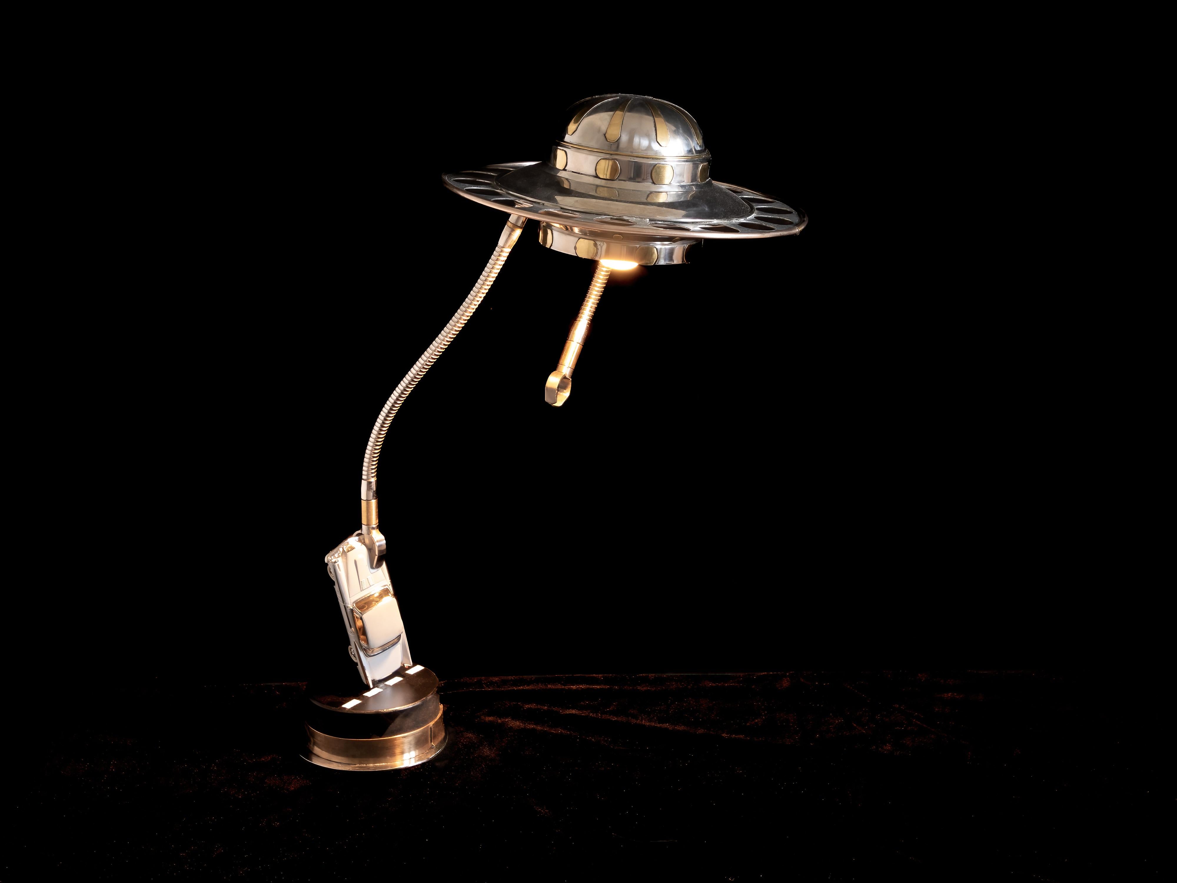 Cette lampe de bureau ludique est un hommage aux films de science-fiction des années 1950. 
Les ajouts les plus récents peuvent inclure un panneau stop hexagonal... et avec notre amour de tout ce qui est américain, ce qui inclut quelques impacts de