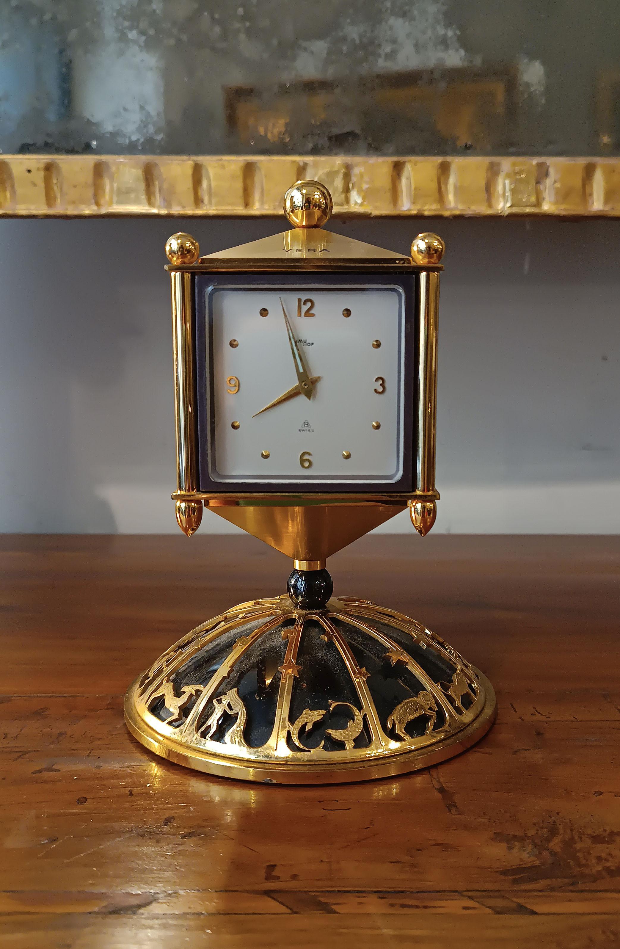 This golden metal desk clock is an elegant and functional small object. The square head is rotatable and has four faces, each of which has a specific function. In addition to telling the hours, in fact, this small object is also a barometer, a