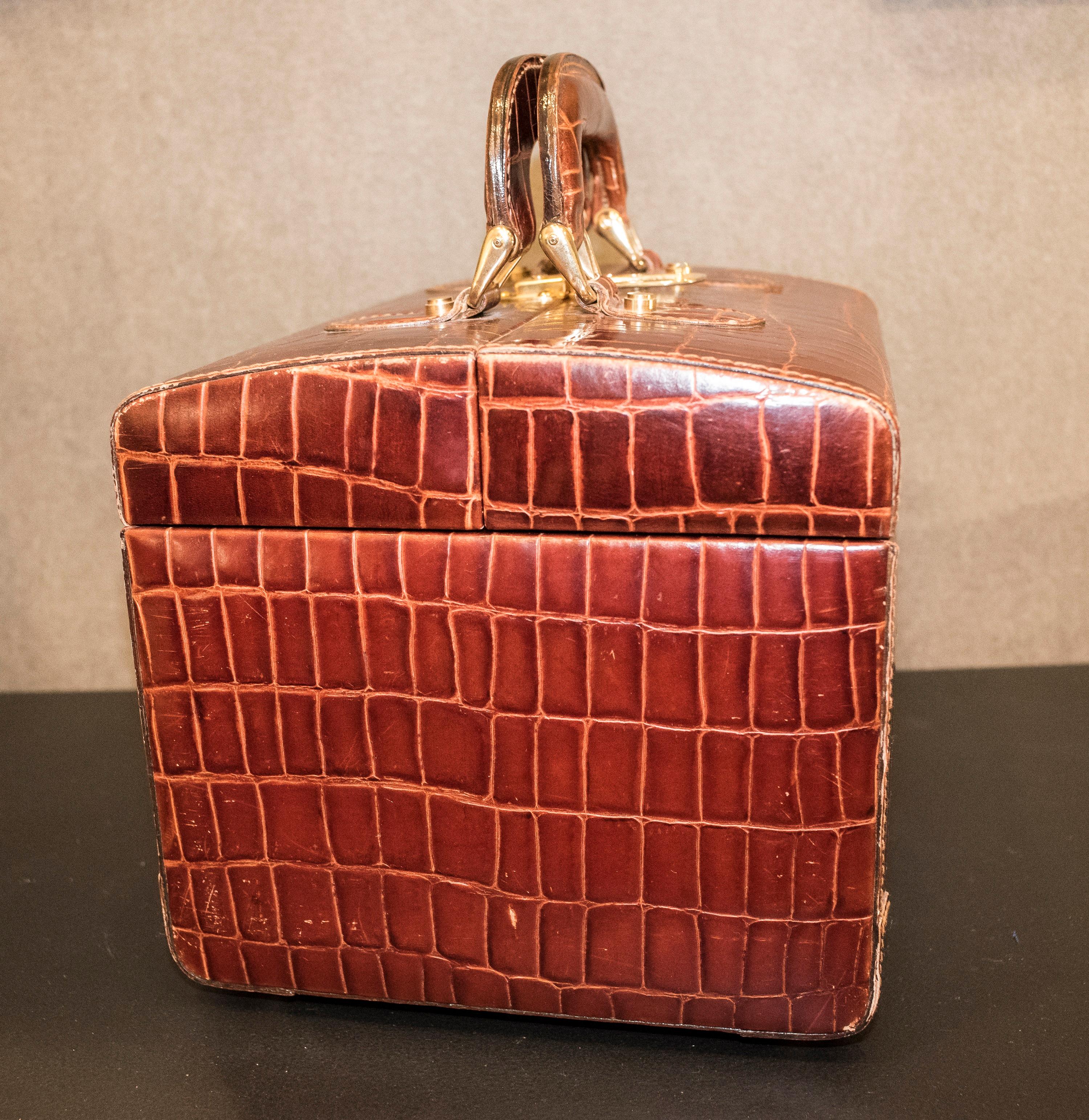 Beautiful and timeless Italian brown leather vanitycase or jewelry box by Marco Tahini, label inside.
Box-shaped vanitycase in leather worked in snake effect. Inside there are several department, a removable try and a mirror. With handles and gold
