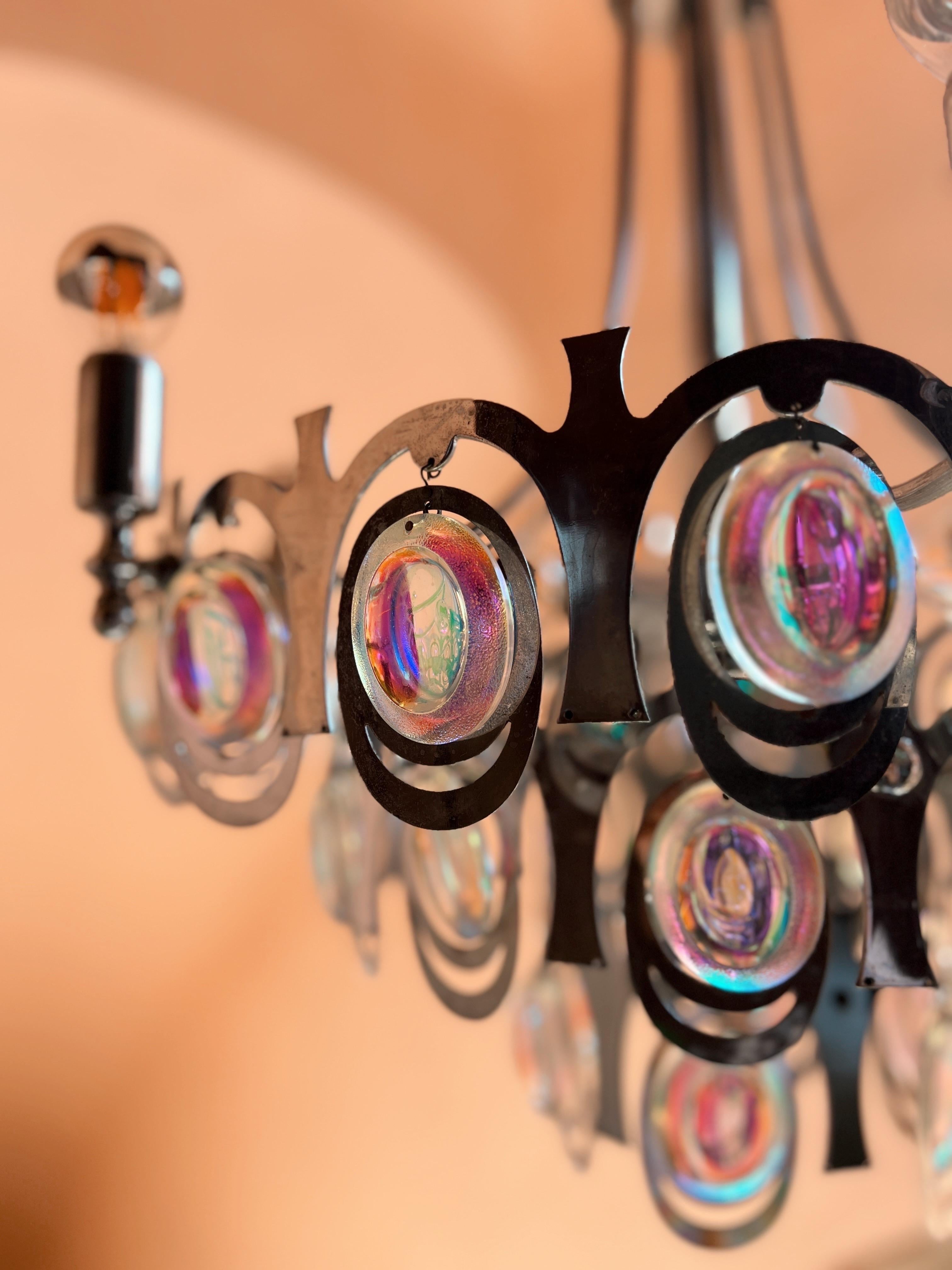 Presenting a remarkable 1960s chandelier designed by Gaetano Sciolari. This exceptional light boasts 38 crystal glasses that possess a amazing rainbow effect. When bathed in light, these crystal glasses create a stunning, ever-changing spectrum of