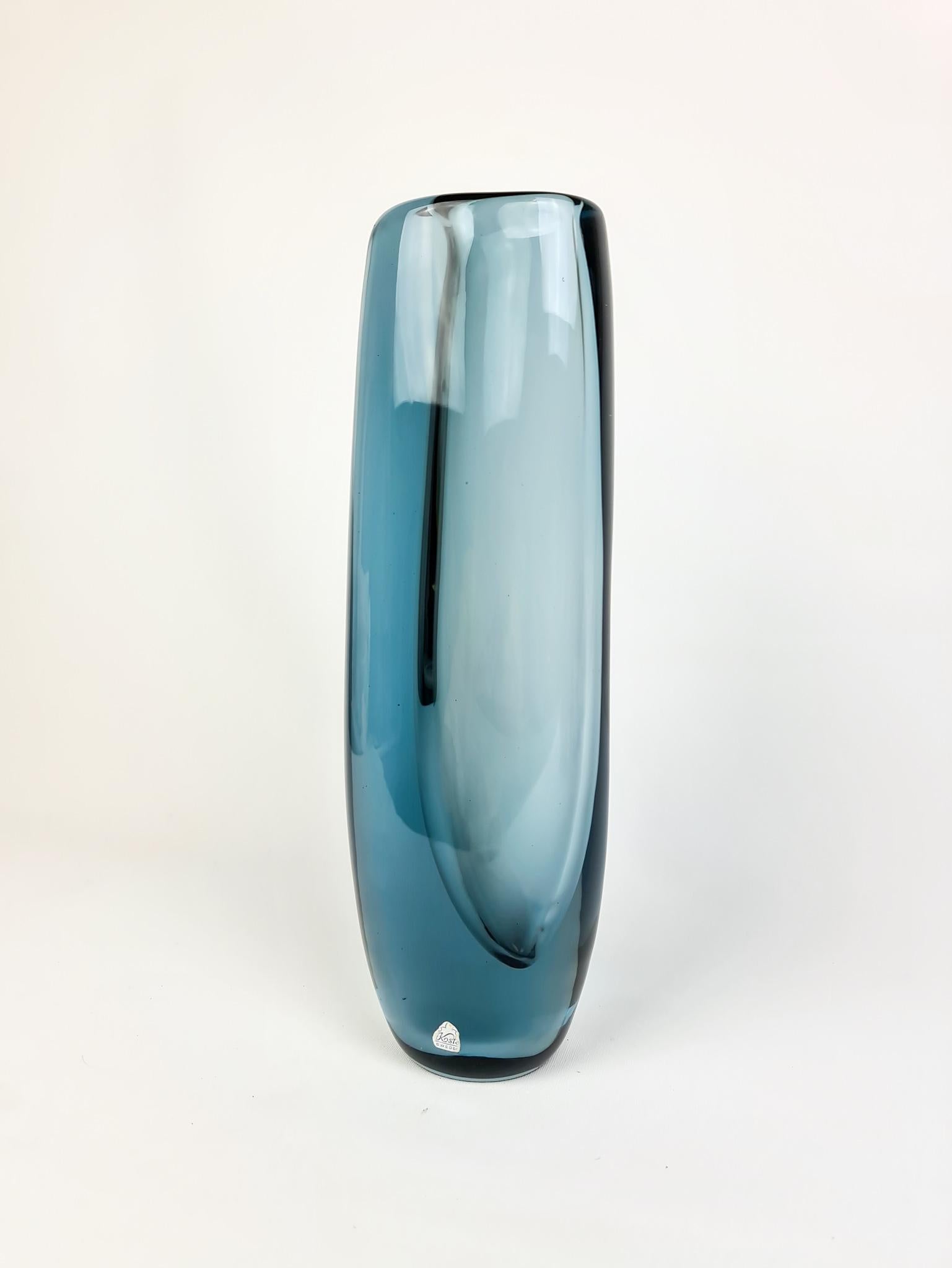 Wonderful clear blue vase produced in Sweden at the Kosta factory. Designed by Vicke Lindstrand.
The piece is made of clear and blue glass. 

Signed on the bottom Kosta LH 1608

Small scratches and wear. 

Measures: Vase H 29 cm, W 11 cm, D 5