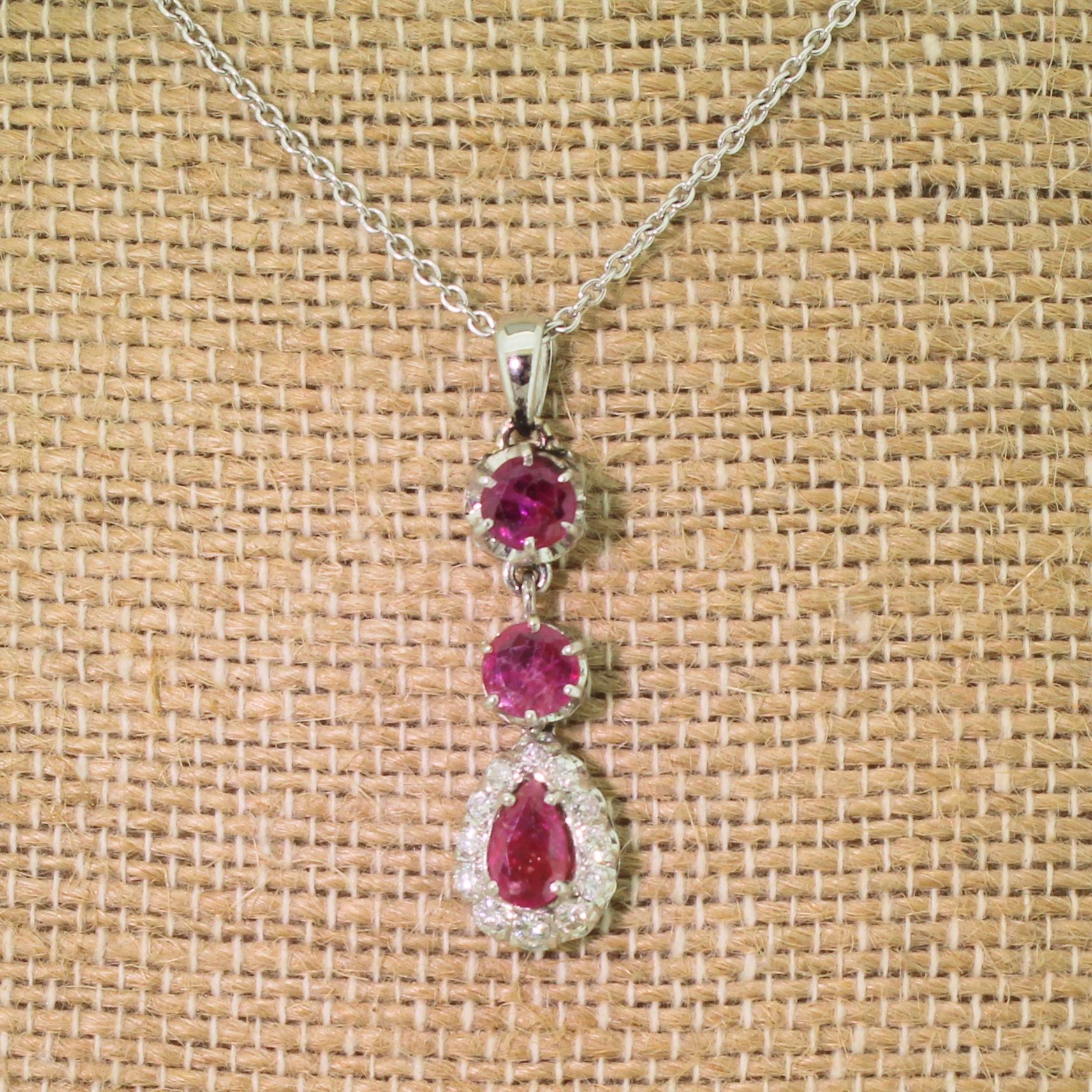 A delightfully pretty ruby and diamond pendant. Two round ruby rubies are set at the top of the articulated pendant, leading to a pear cut ruby bordered by twelve brilliant and eight-cut diamonds of graduating size.

Please choose a 16 or 18 inch