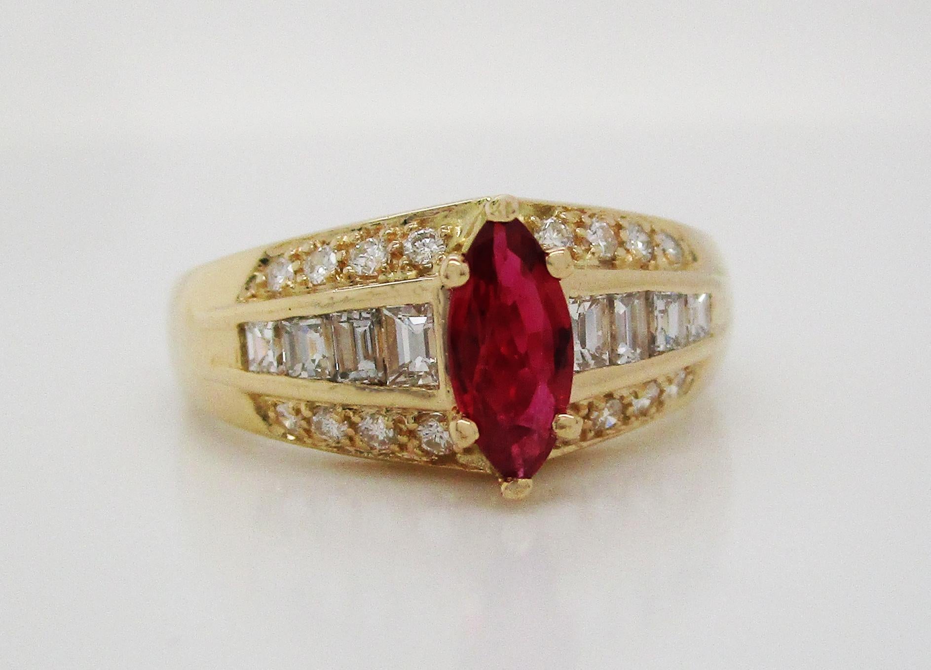 This remarkable mid-century ring is in 14k yellow gold and is set with three rows of stunning diamonds and a gorgeous deep red marquise ruby center stone. The ring features a graduated center row of baguette diamonds, on either side of the ruby