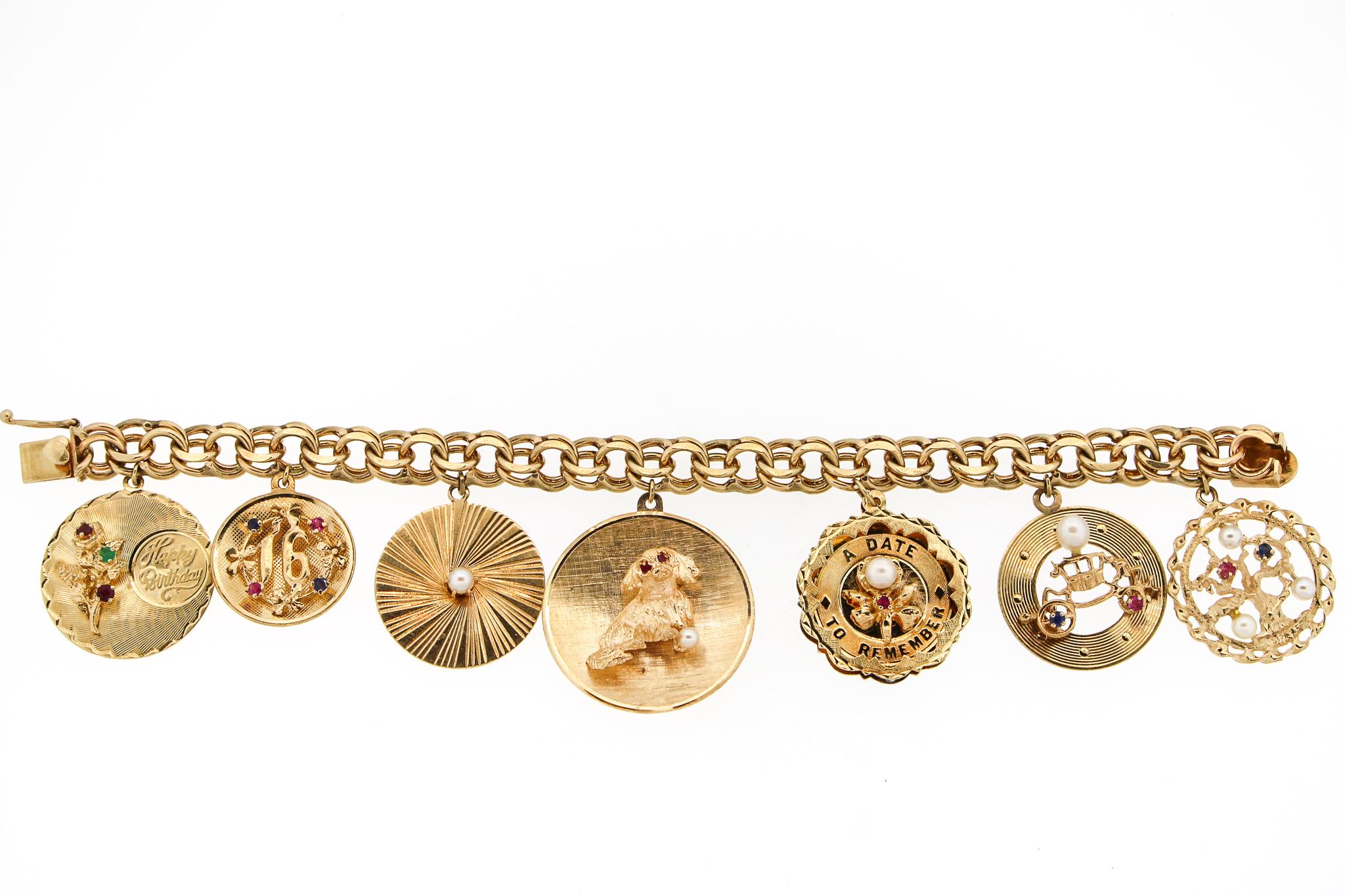 A wonderful and complete grouping of 1960's charms on a vintage 14k gold bracelet. The bracelet has 7 round 14k charms. The charms range from 1.25 inches wide to a little under 1 inch wide. There is a Happy Birthday charm, a sweet 16 charm, a pearl