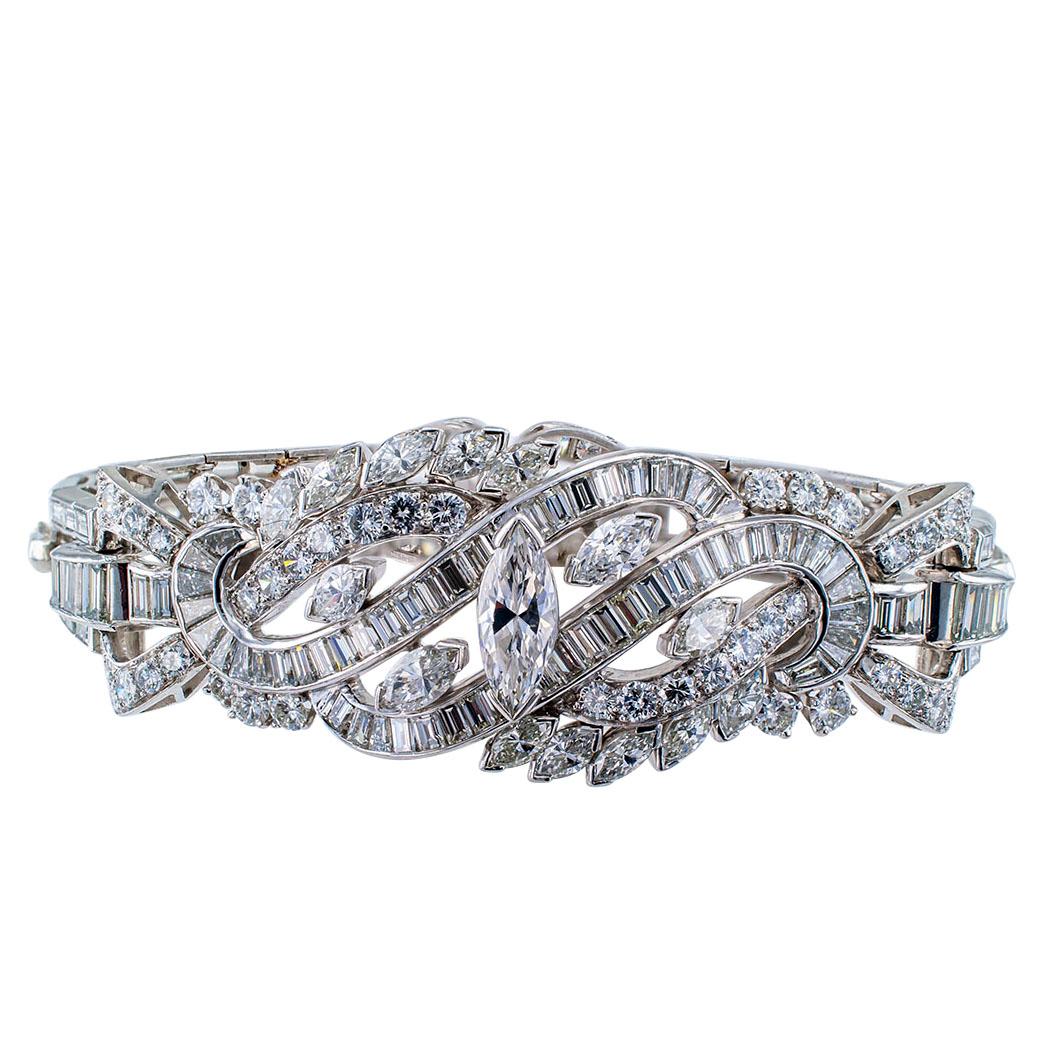 Midcentury 16.00 carats diamond and platinum bracelet circa 1950. The articulated design centers upon a larger marquise-shaped diamond framed by scrolling motifs, connectors and elongated links, entirely set with baguette, marquise and round