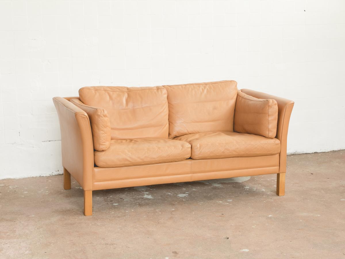 Midcentury sofa designed and manufactured by Mogens Hansen in Denmark in the 1960s. The sofa has nicely curved armrests. It is handmade high quality. The sofa is in light brown aniline leather and in very good condition.