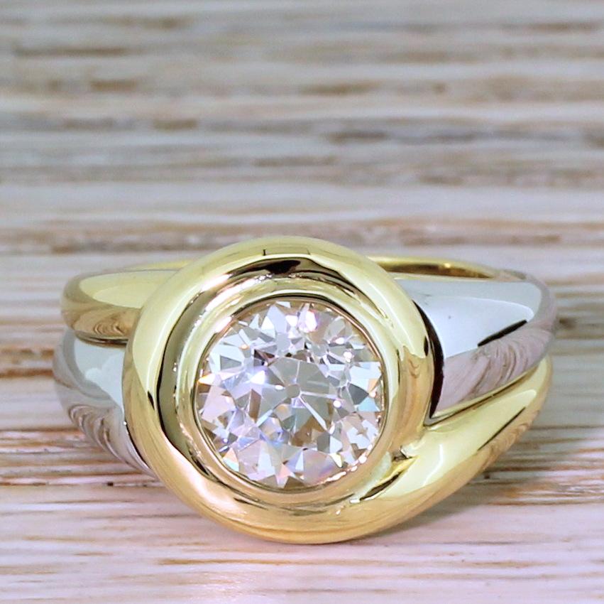 A big, bold and brilliant old European cut diamond solitaire ring. The 2.04 carat diamond in the centre – graded by HRD as L colour, SI2 clarity – is rubover set in yellow gold within a stylishly swirling surround. The elegant and chunky mount is