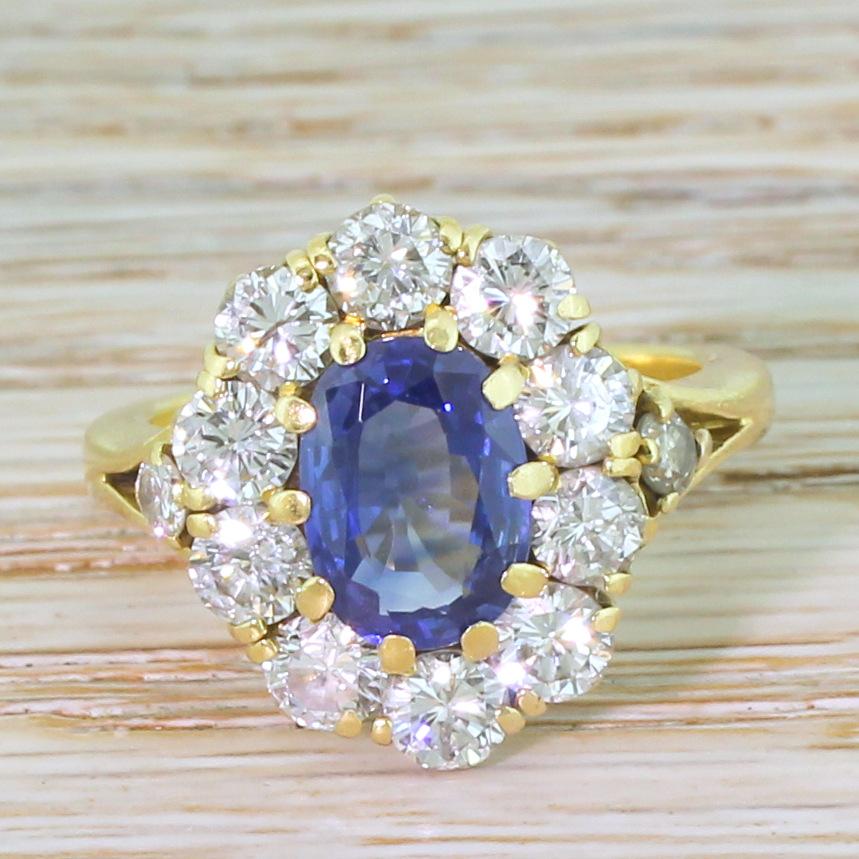 A magnificent sapphire and diamond ring. The oval cut sapphire ring the centre is the perfect blue; strong, bright and richly saturated. The colour of the centre stone is emphasised by the whiteness of the ten dazzling round brilliant cut diamonds