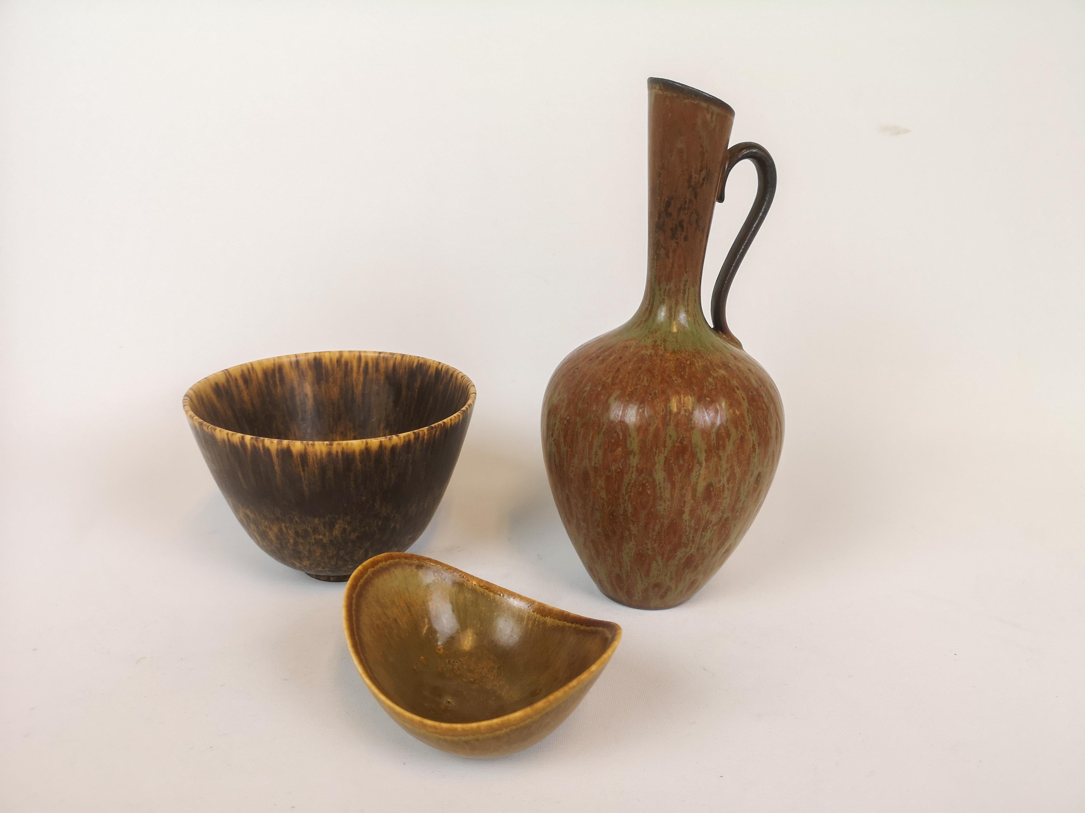 Tres maravillosas piezas fabricadas en Suecia durante los años 50 en la fábrica de Rörstrand y diseñadas por Gunnar Nylund.

Los objetos tienen una forma y un vidriado maravillosos. 

Buen estado. 

Medidas: Jarrones A 23, P 10, cuenco A 9 cm,