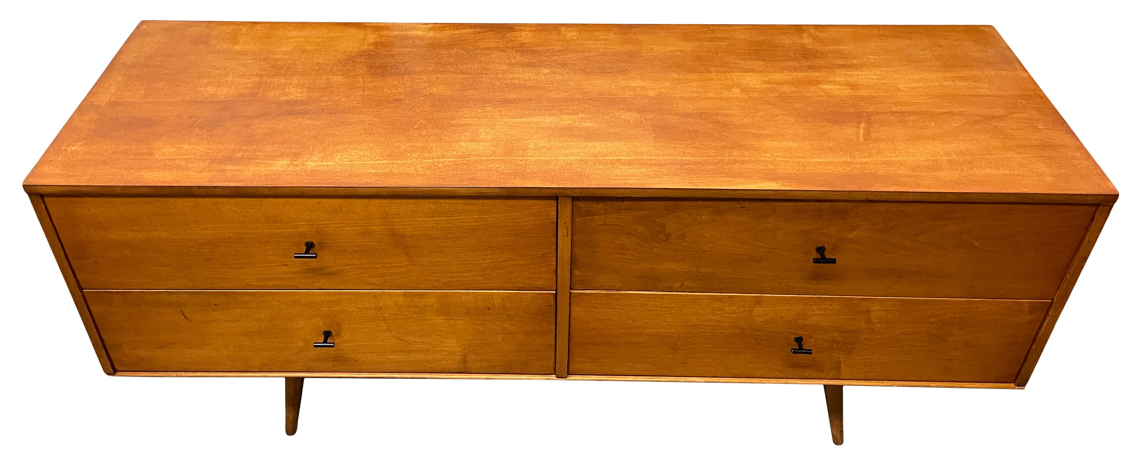 Rare midcentury low dresser credenza by Paul McCobb circa 1950 Planner Group #1504 with 4 low drawers - solid maple construction has a tobacco blonde maple lacquered finish. All original Black Steel T Pulls. Sits on a 60