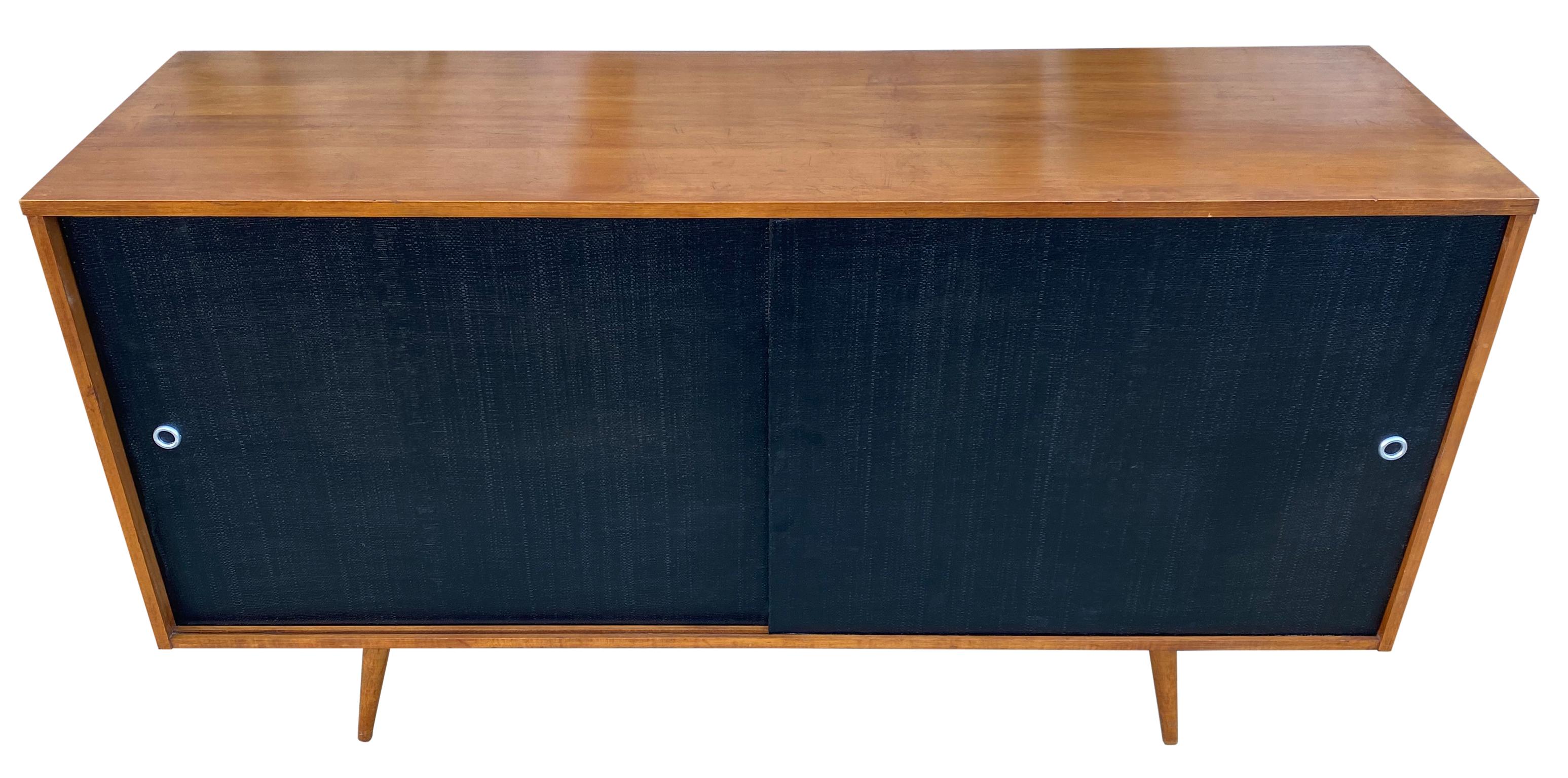 Beautiful midcentury credenza by Paul McCobb circa 1950 Planner Group #1514 has 1 adjustable shelves with pins with 1 drawer on the left side and 3 drawers on the right side. Solid maple construction has a Tobacco maple finish. All original black
