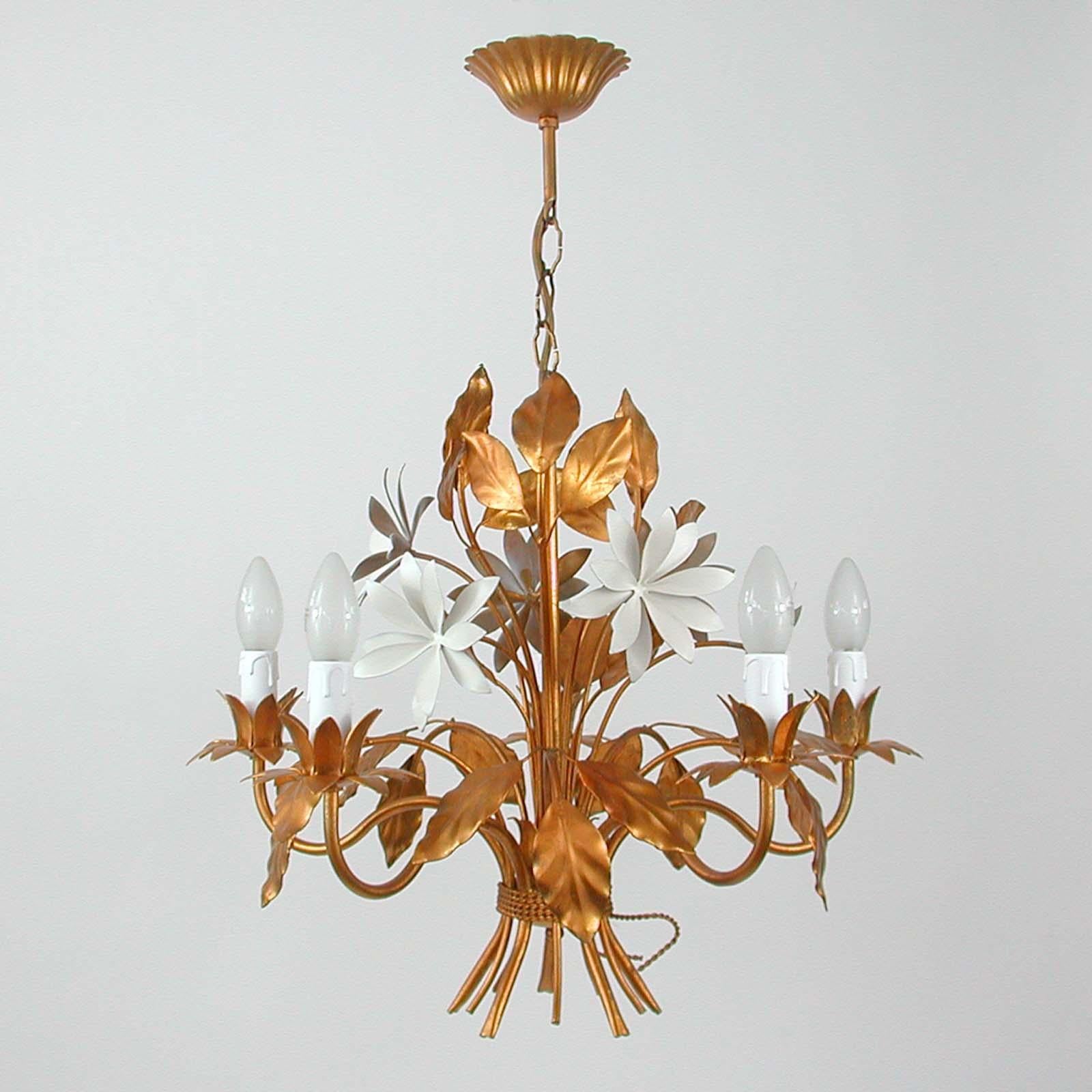 Ce magnifique lustre doré a été conçu et fabriqué en Allemagne dans les années 1970 par Hans Kögl Leuchten. Il comporte 5 lumières et est fait de métal plaqué or antique et de fleurs laquées blanc cassé. 

Les dessins de Kögls s'inspirent de