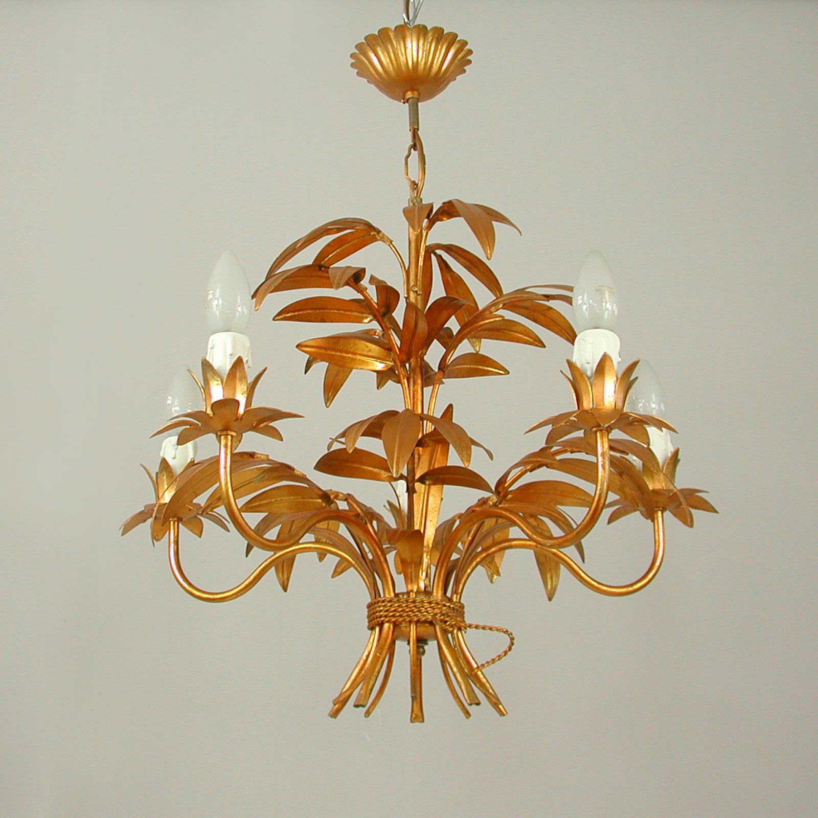 This beautiful gilt chandelier was designed and manufactured in Germany in the 1970s by Hans Kögl Leuchten. It features 5 lights and is made of antique gold-plated metal. 

Kögls designs were inspired by natural shapes such as sheaf of wheat or