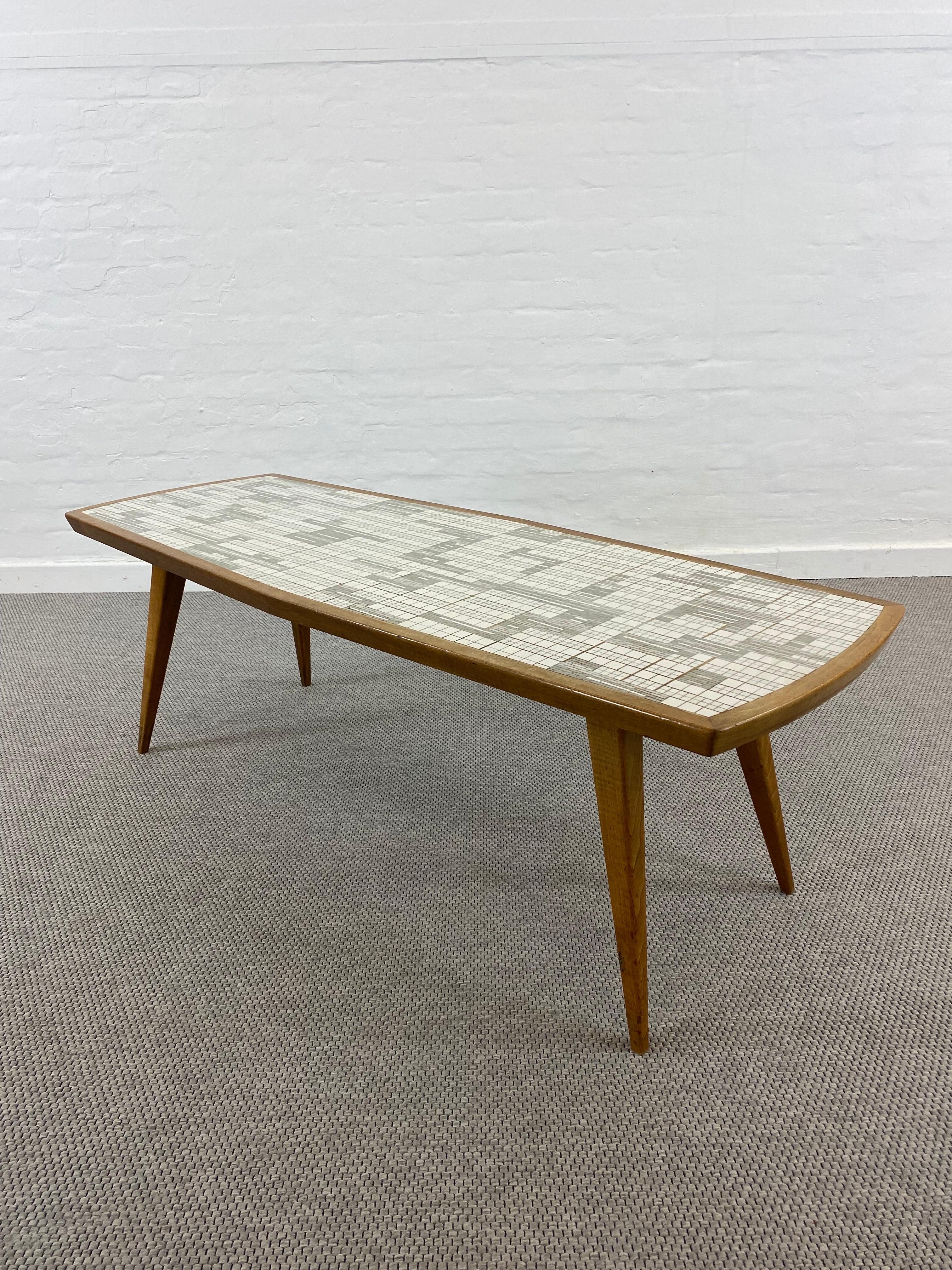 A 1950s Glas-Mosaic table by German Artist Berthold Muller-Oerlighausen (1893-1979).
The rectangular wooden base or structure of this iconic midcentury furniture is also stabile and elegant.
The glas tiles inlay give this table a modern look and