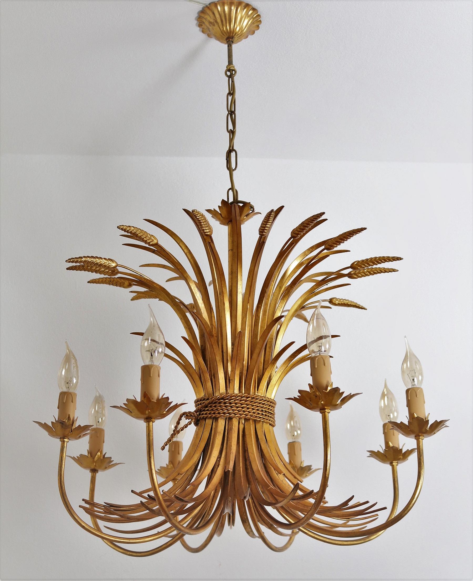 A large Hollywood Regency eight-arm light fixture from Italy manufactured in mid-century in between the 1960s-1970s. Fits with the interior style from Coco Chanel.
The chandelier has the shape of a bunch of wheat sheafs spread out upwards and eight