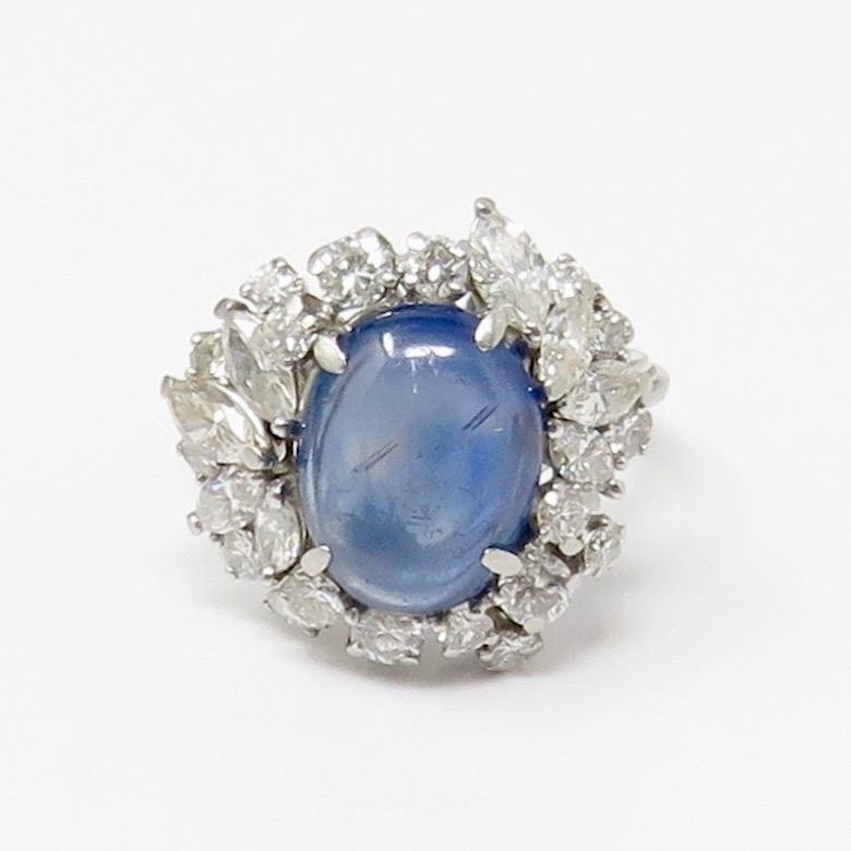 Stunning midcentury 1950's estate natural blue star sapphire and diamond cocktail ring.  This gorgeous platinum set ring holds a large blue star sapphire cabochon measuring 9.4 x 12.2 x 4.3 mm, totaling approximately 5.5 carats.

Around the