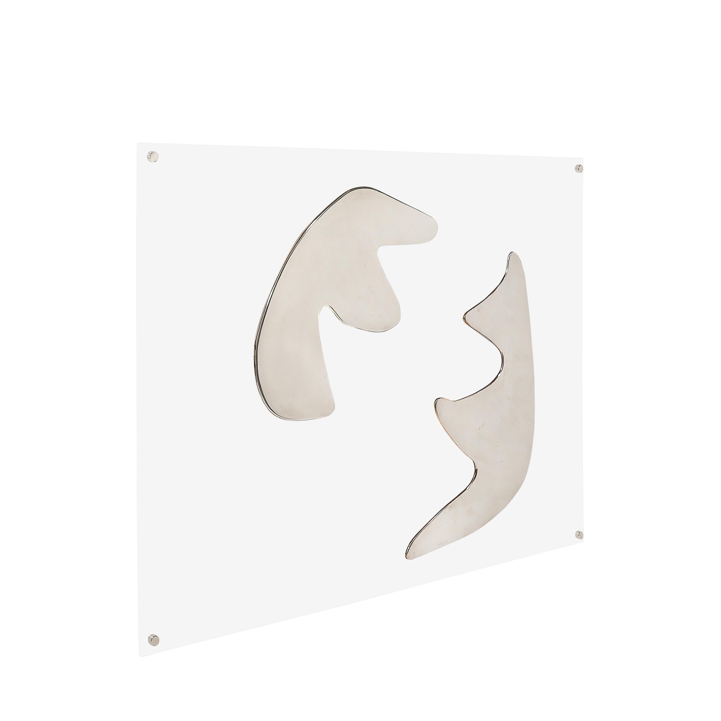 This striking Mid-Century Modernist wall sculpture, completed by American artist Harold Sclar in 1971, is an elegant fusion of geometry, abstraction, and material innovation. Crafted from chrome and Lucite, the sculpture reflects the bold
