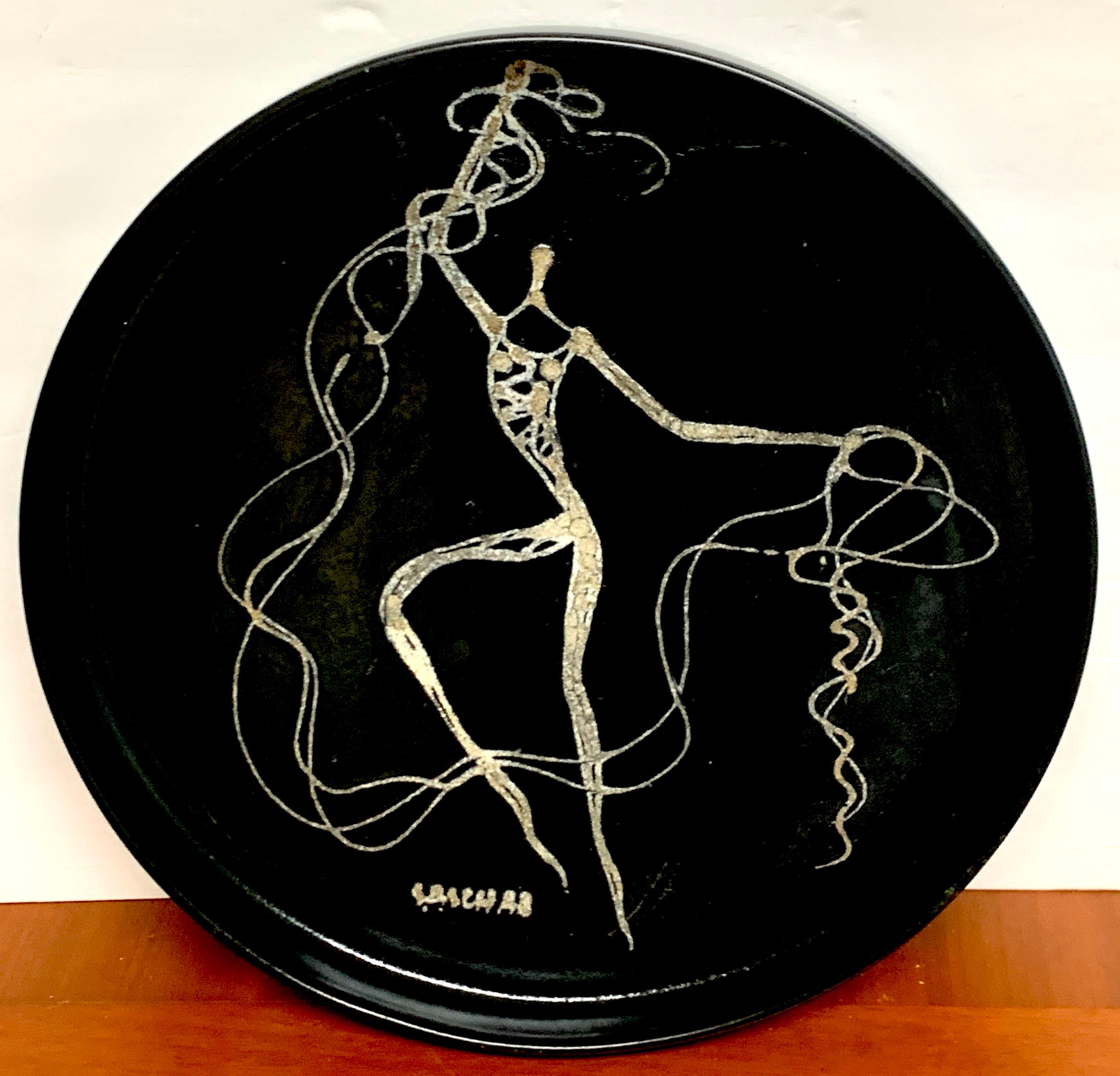 Midcentury abstract nude circular gallery tray by Sascha Brastoff, decorated in white slip on black background, signed on the front 'Sascha'.
