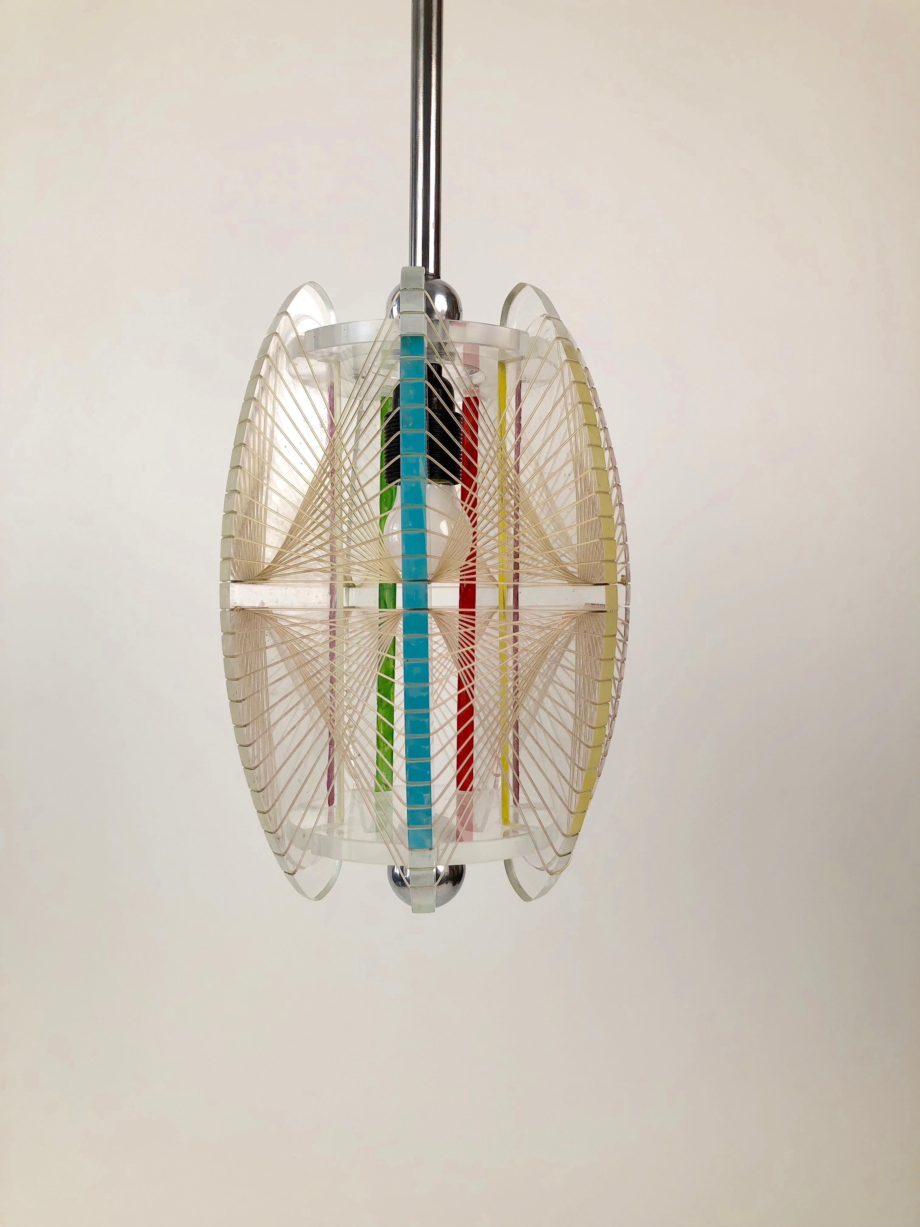 This unique acrylic and mono filament, pendant lamp comes from the Czech Republic. Made in the 1950s, the details are what make it interesting. The two metal balls at the top and bottom of the shade accent the acrylic shape while the stripes bring