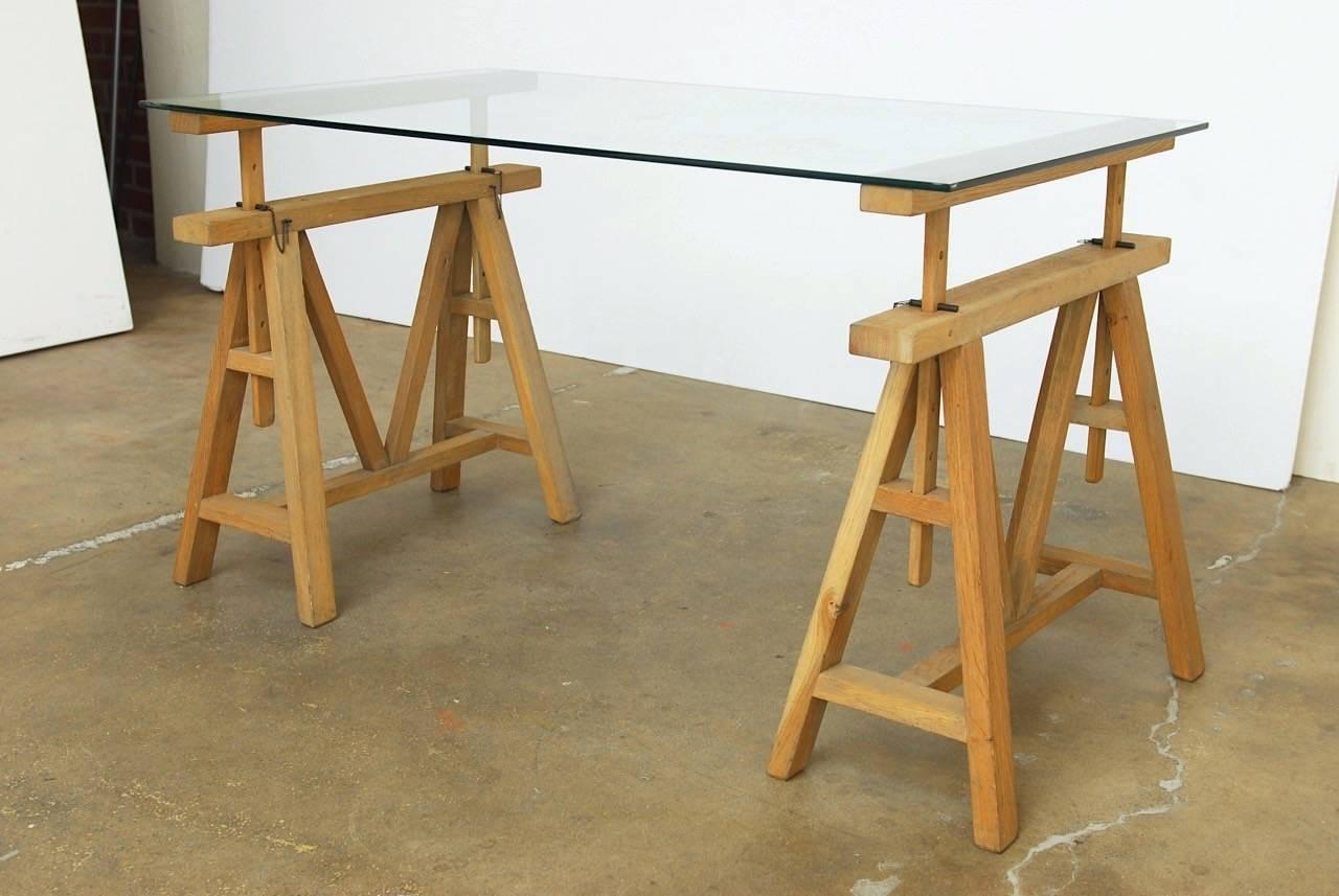 Mid-Century Modern French oak sawhorse desk or writing table with adjustable height sawhorse bases. These architectural style bases have five height settings that adjust from 25.5