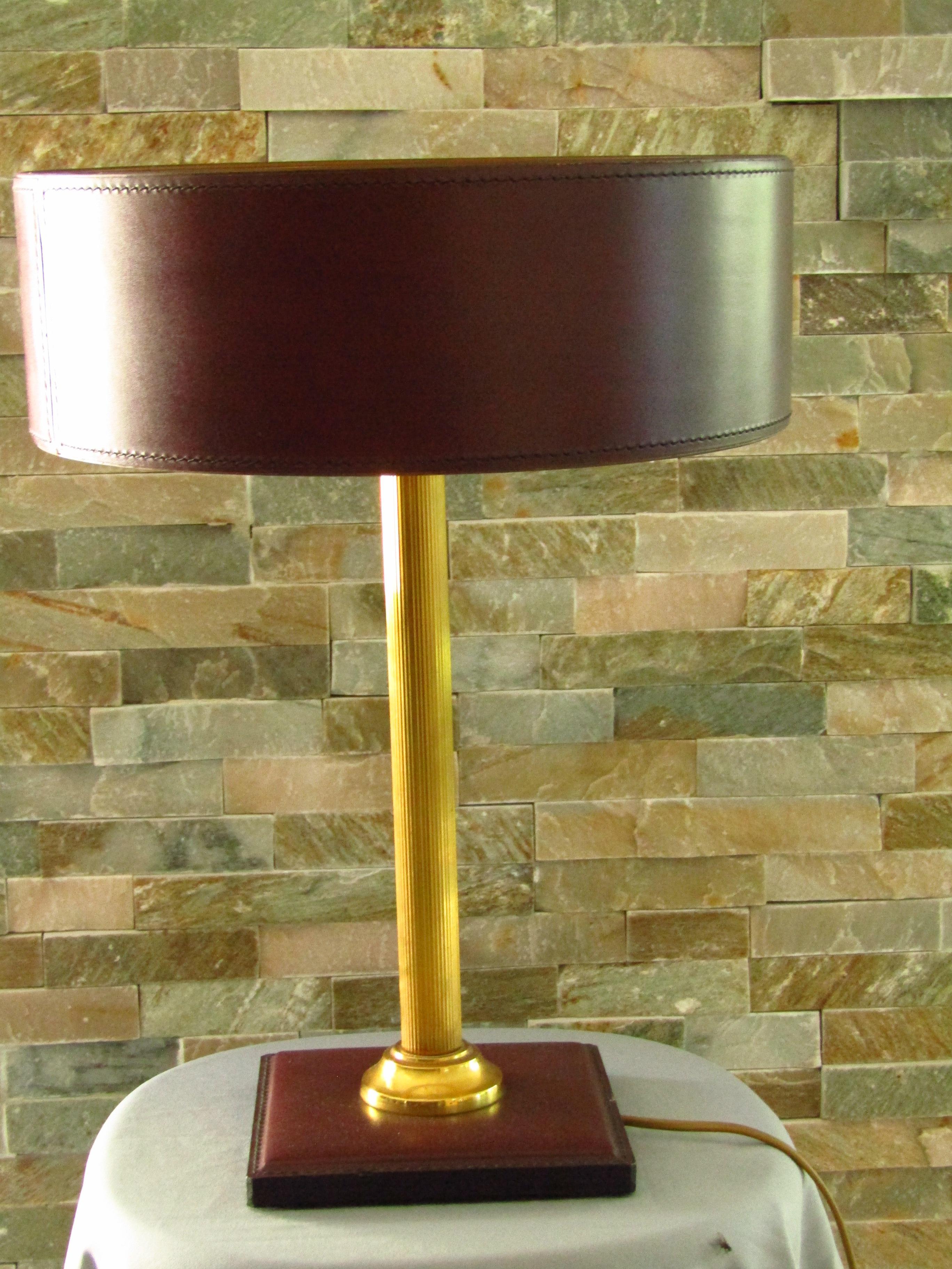 Mid-Century Adnet desk lamp leather and brass. Published by Tanneur, France, circa 1958. Bordeaux colored leather, hand-stitched, interior gold.

Free shipping any where in the world for this item!