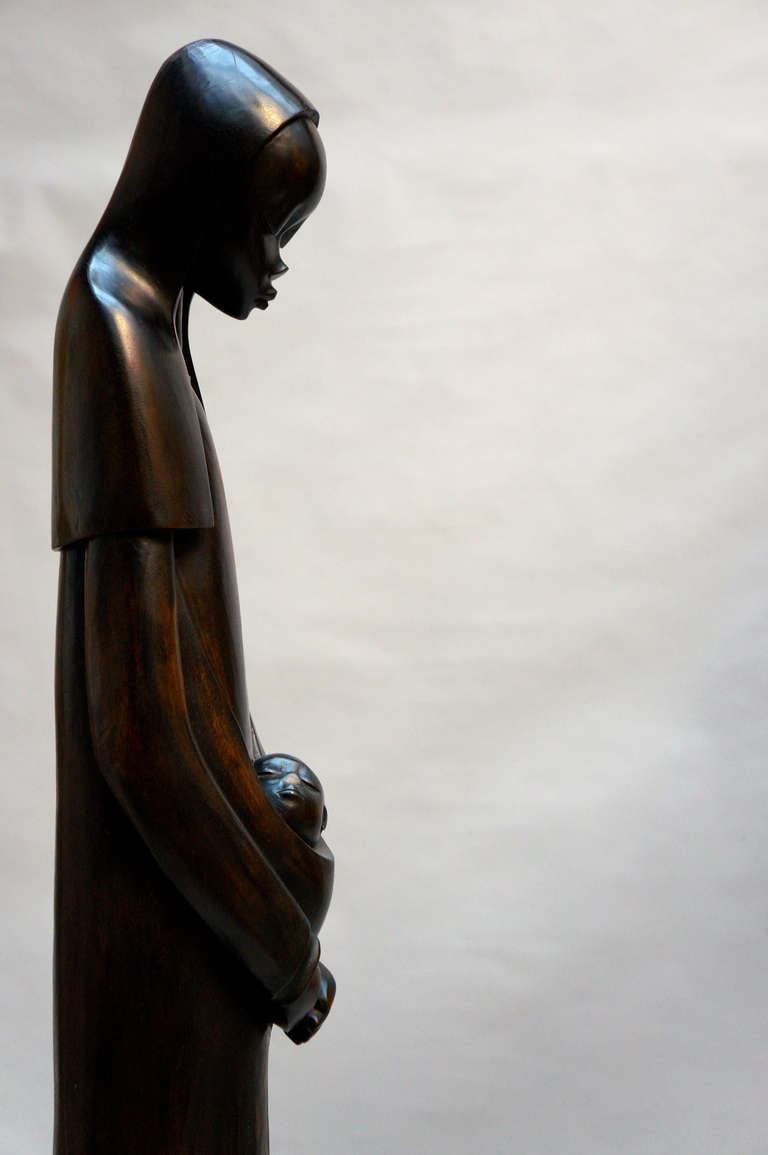 Sculpture africaine en bois du milieu du siècle, merveilleusement sculptée à la main, représentant la Vierge Marie avec l'enfant, avec de grands détails et un beau visage, signée par Par Makengo-B.
Congo, années 1930-1950.
Mesures : Hauteur 138