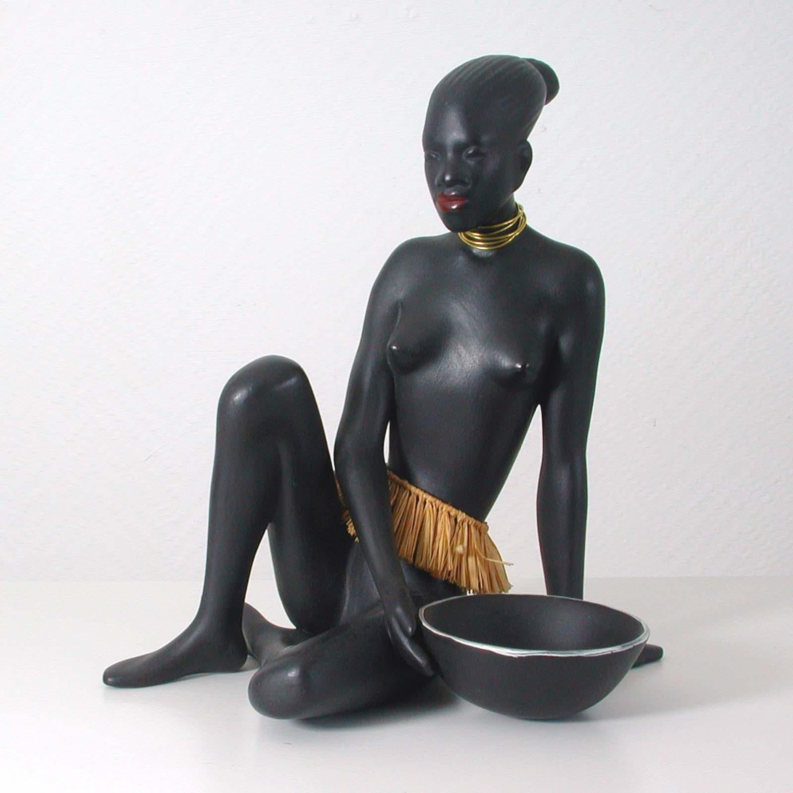 This beautiful sculpture was designed and manufactured in Germany in the 1950s by Porzellanfabrik Cortendorf Julius Griesbach in Coburg. Designer was Albert Strunz. Model no. 2512.

It features a nude African native woman with raffia skirt,