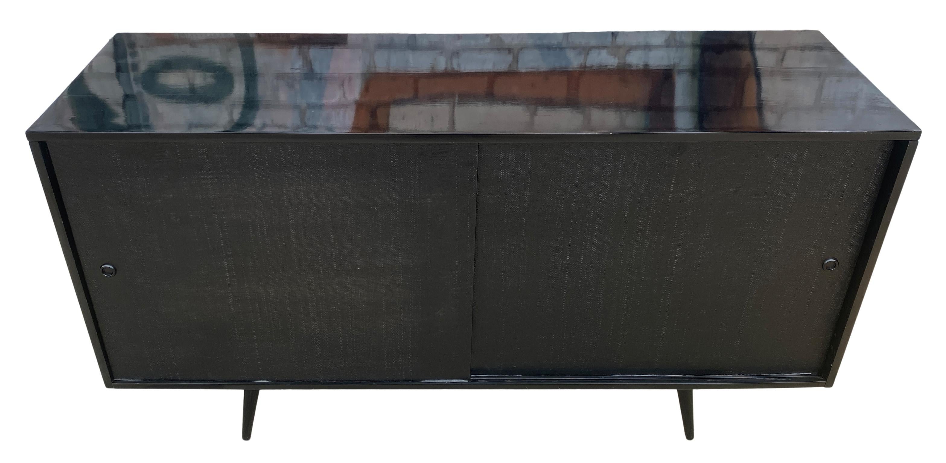 Beautiful midcentury tall credenza by Paul McCobb circa 1950 Planner Group #1514 has 1 adjustable shelves with pins with 1 drawer on the left side and 3 drawers on the right side. Solid maple construction with a high gloss black lacquer finish. All