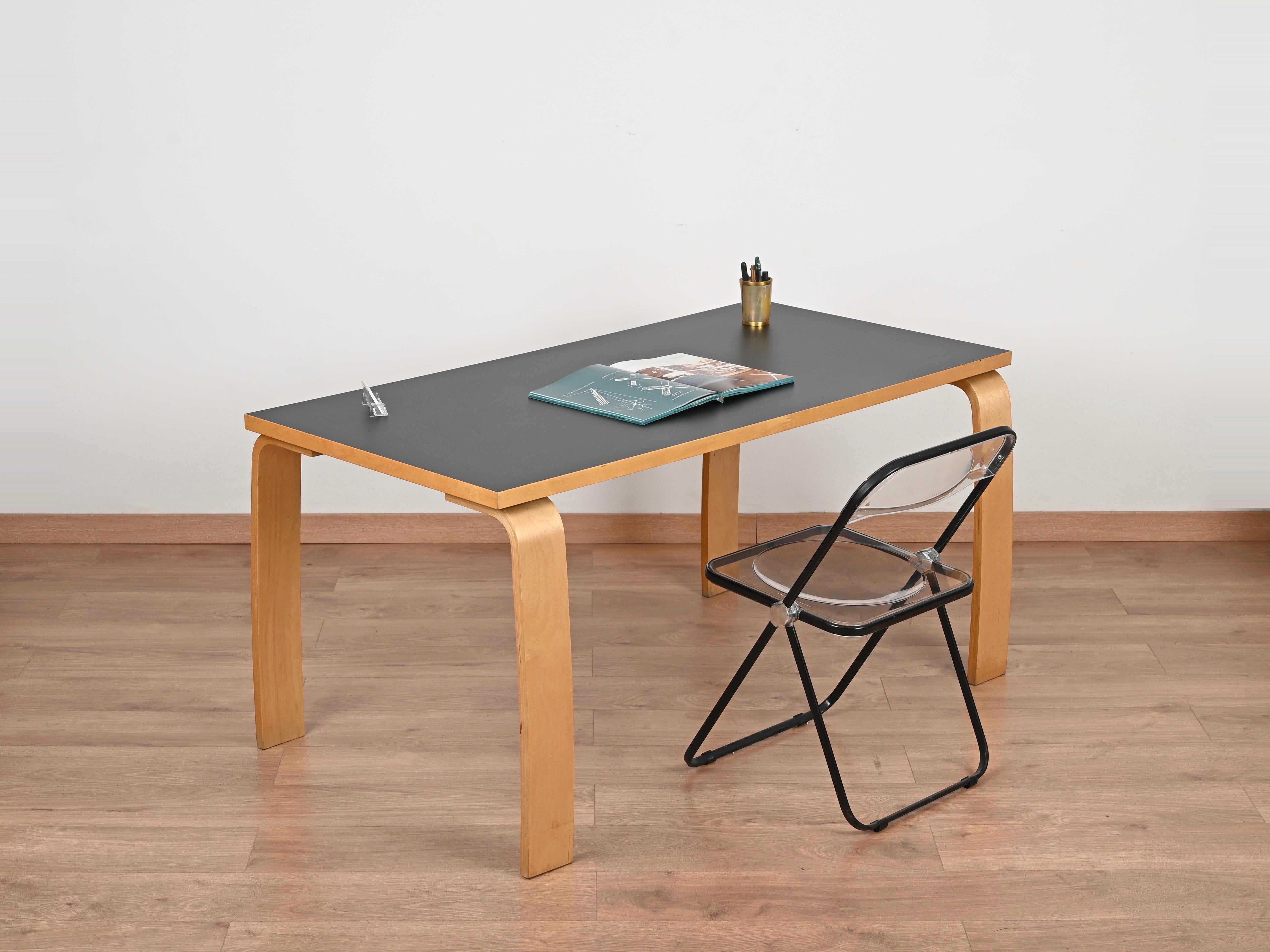 Stunning mid-century desk or dining table in curved beech wood with black laminated top. This incredibly elegant table was designed by Alvar Aalto for Artek and produced during the 1970s.

Fully original and in fabulous conditions. The smart design