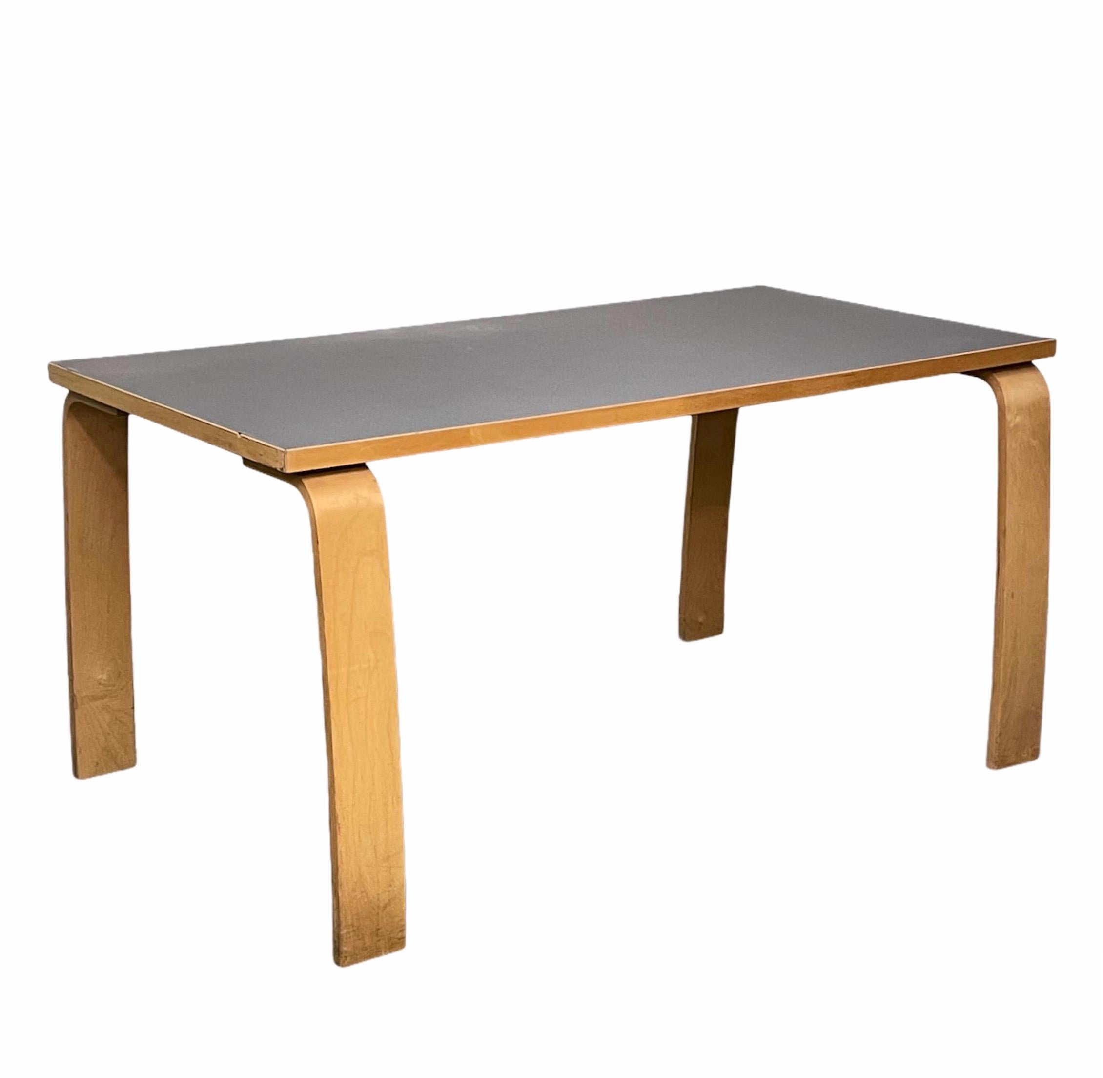Wonderful midcentury wood dining table with grey formica top. This fantastic piece was designed in the style of Alvar Aalto in Italy during the 1980s.

You are going to love the clean lines, the straight grey Formica top and the way the legs are