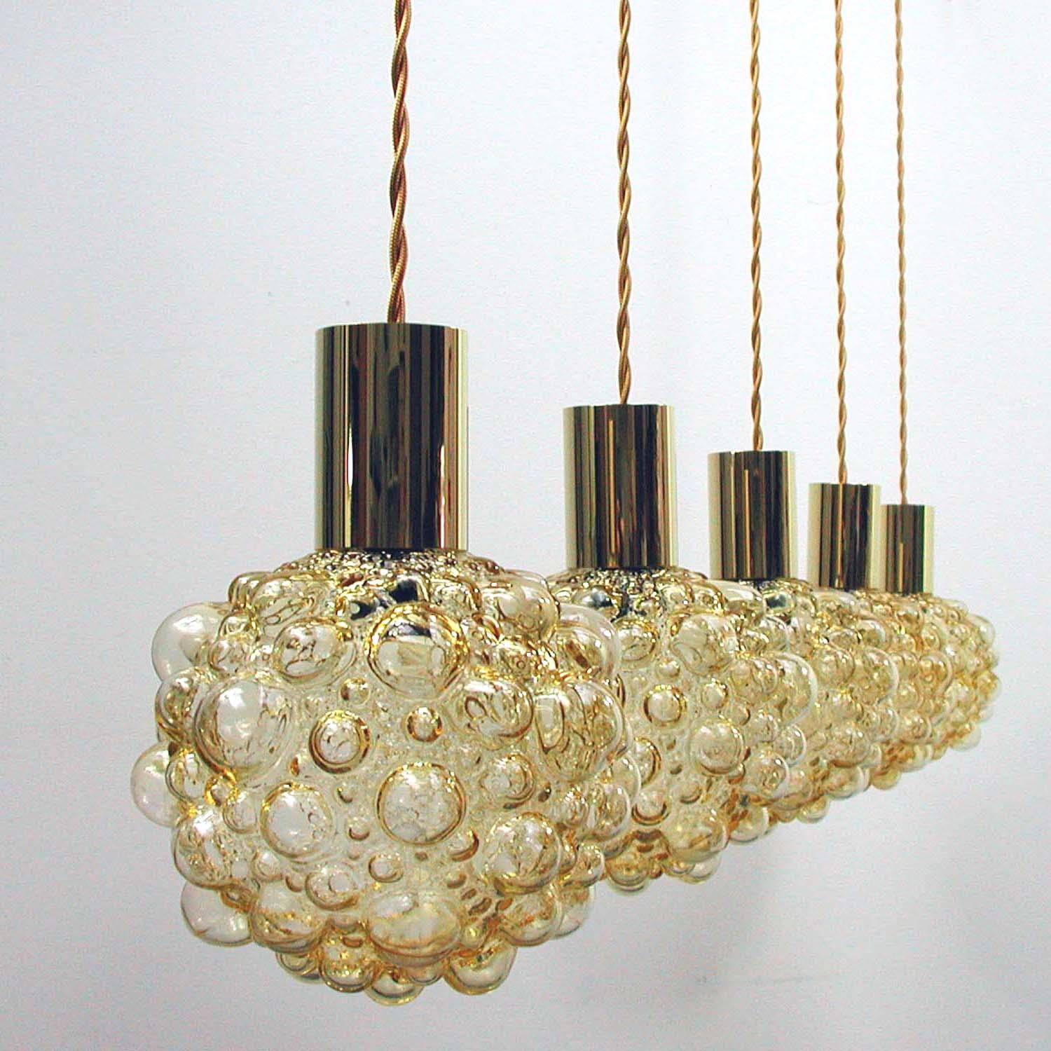 This Space Age pendant light was manufactured and designed during the 1960s in Germany. It is made of amber bubble glass and has got a brass cylinder. The lamp comes without canopy.

The lamp has been rewired with new amber colored fabric cord. It