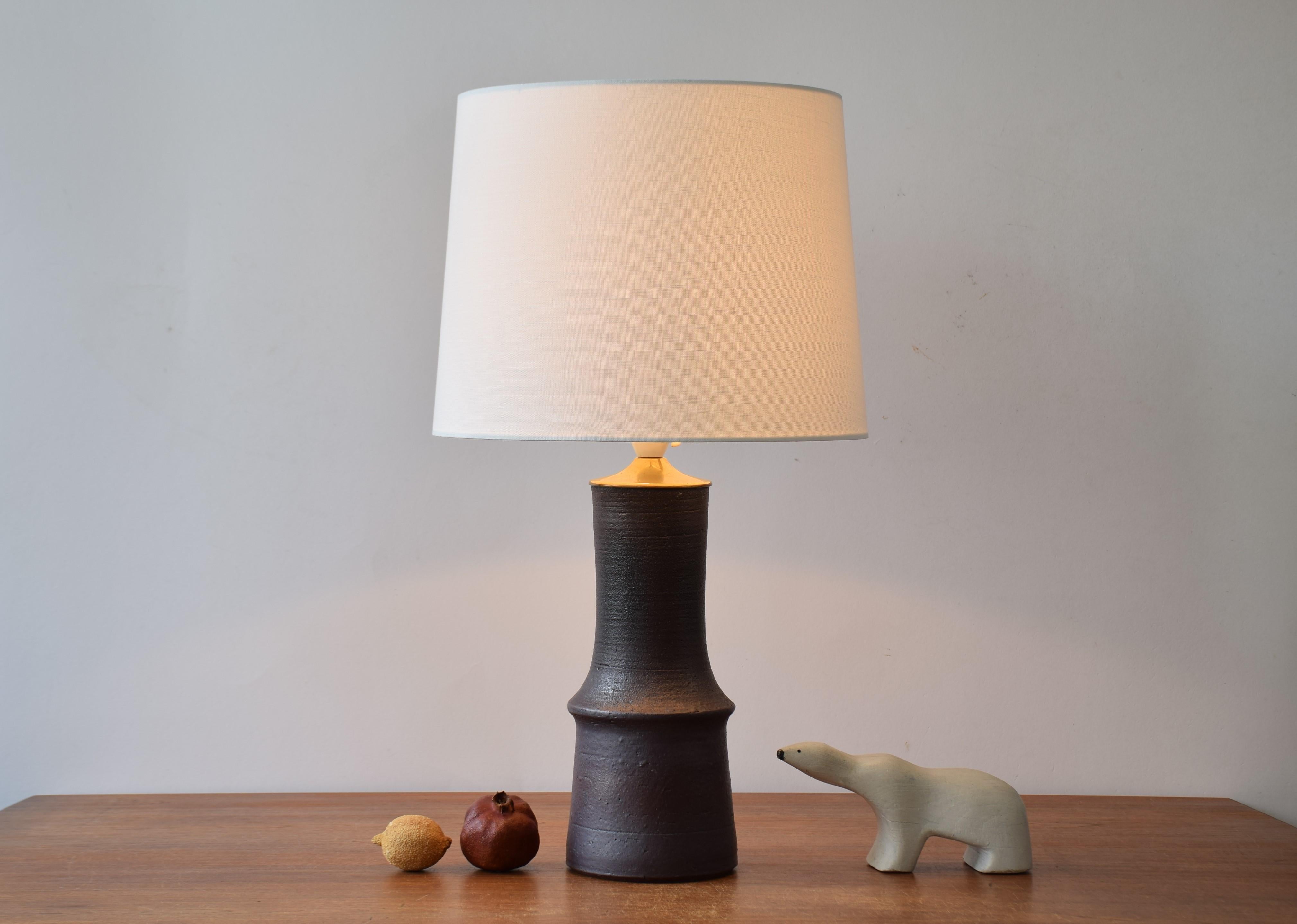 Tall ceramic table lamp by Liisa Hallamaa (1925-2008) for Arabia Finland. Made ca 1960s to 70s.

The lamp has an earthy brown glaze with a rustic surface and a patinated brass top. 

It´s handmarked on bottom LH (for Liisa Hallamaa)