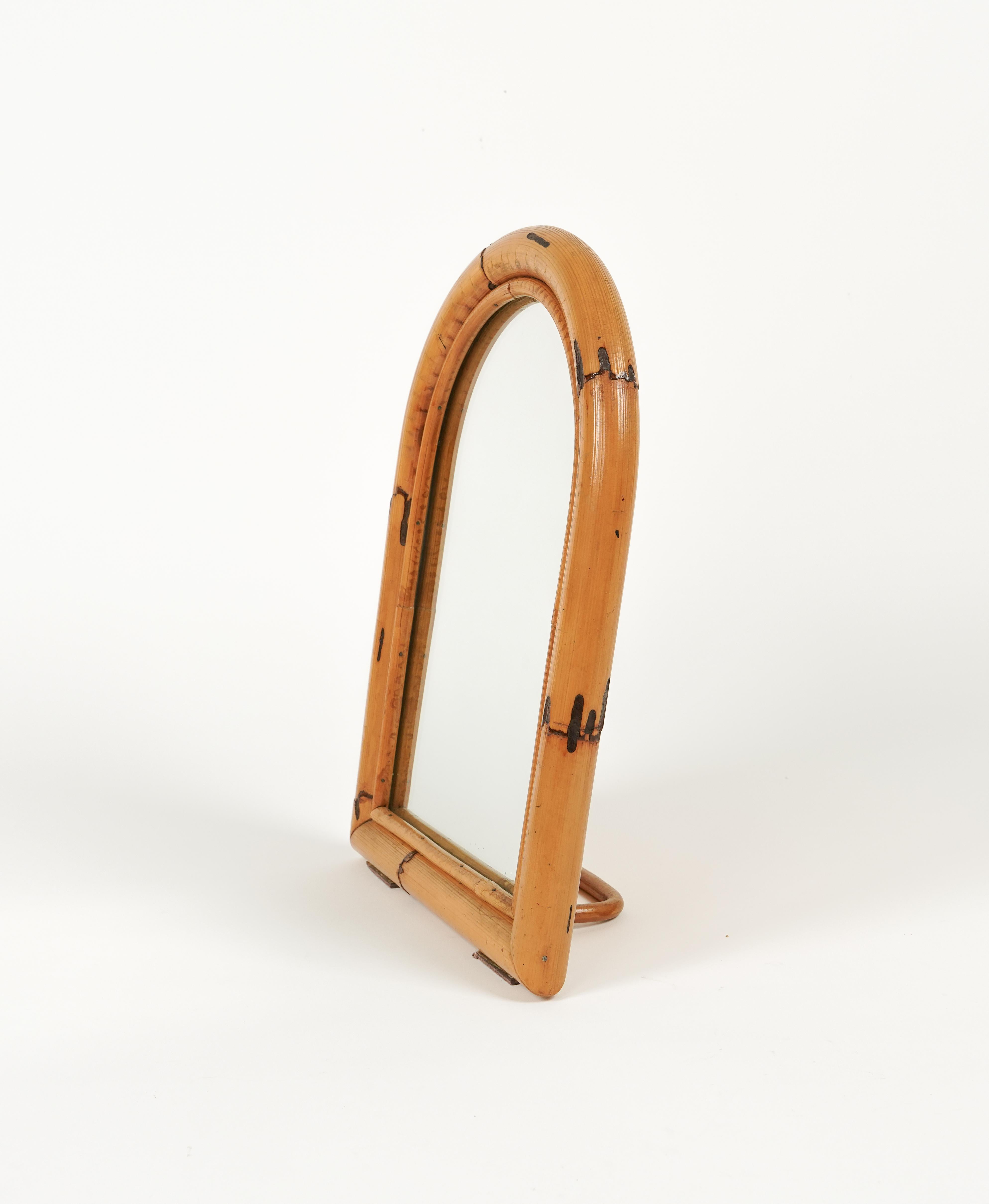 Midcentury beautiful arched table mirror framed with bamboo and rattan.

Made in Italy in the 1970s.
