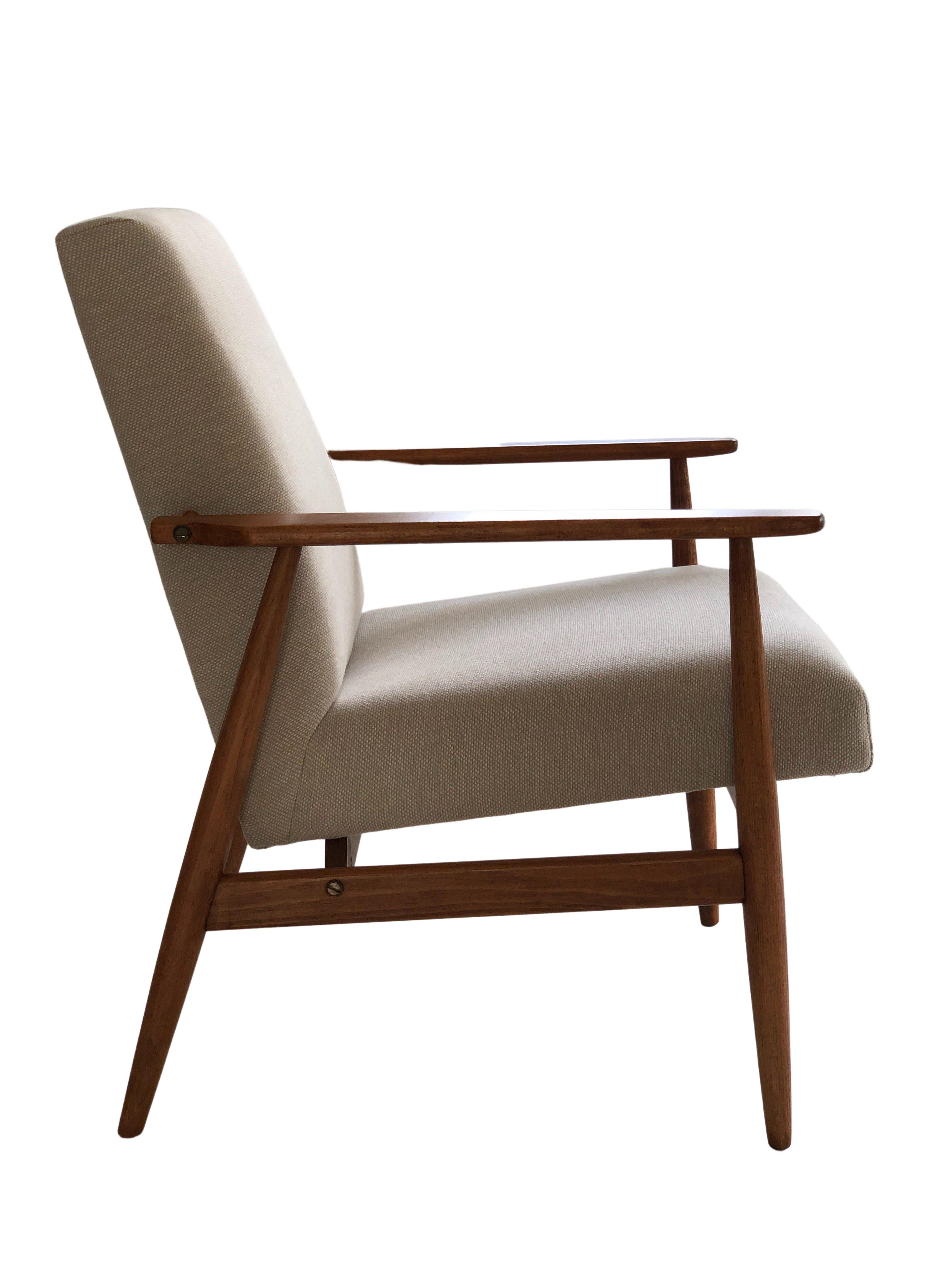 The armchair designed by Henryk Lis. The structure is made of beech wood in a warm walnut color, finished with a semi-matte satin varnish. The upholstery is heavy weight cotton and linen fabric in a beige color. 

The armchair has been completely