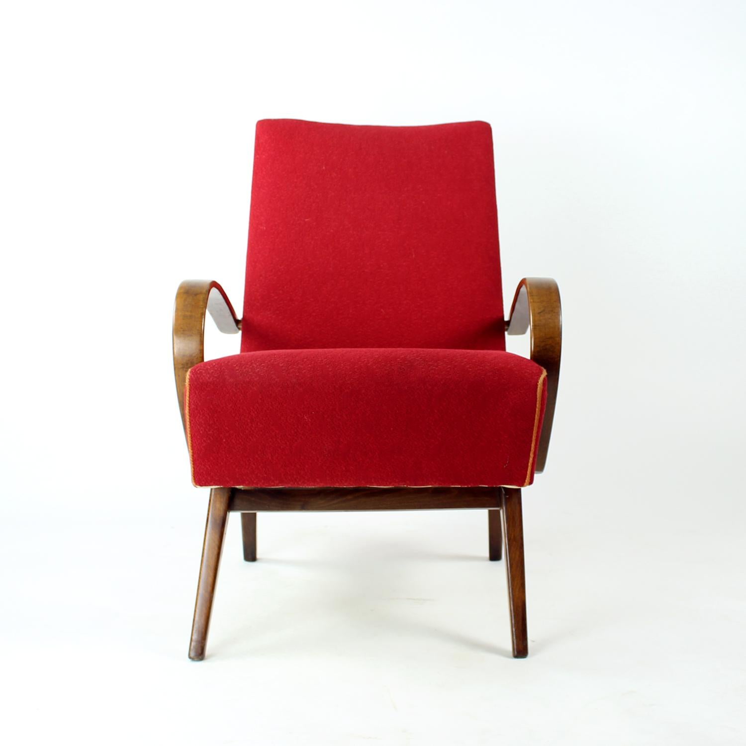 Beautiful red armchair produced by TON company in the 1960s. The armchair is in the original fabric. The wooden parts were partially restored. The fabric shows some minor age wear on the back, but the red fabric still looks beautiful and shows the