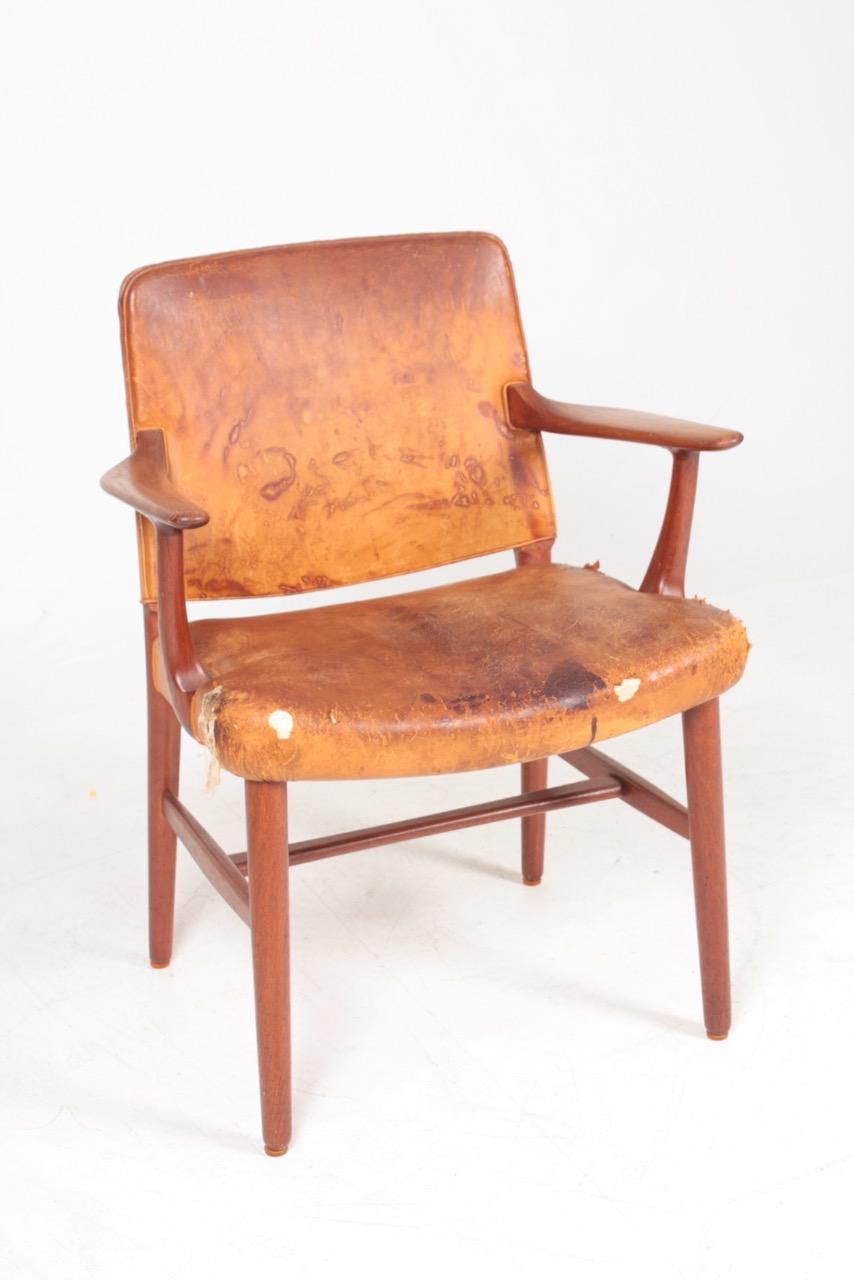 Danish armchair in patinated leather and teak. Designed and made in Denmark, great original condition.