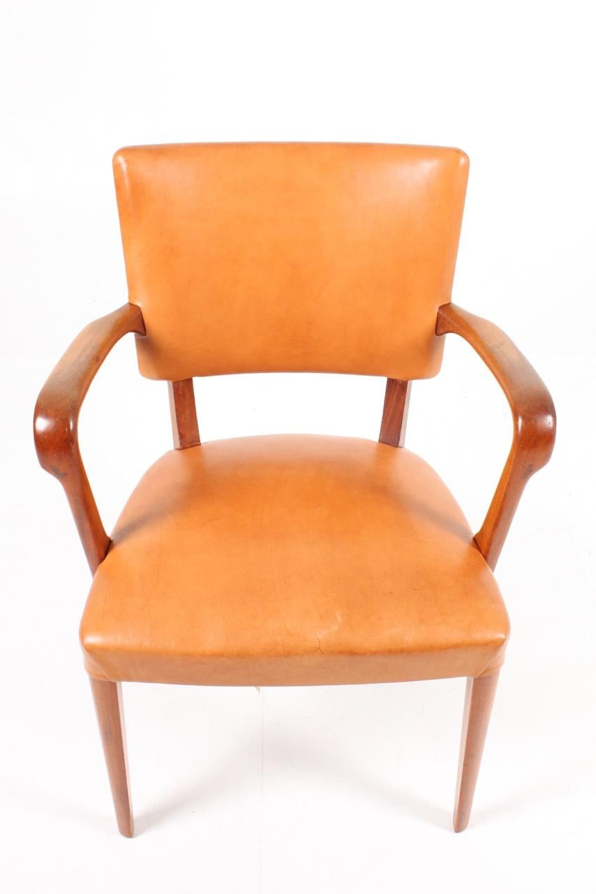 Armchair in walnut and patinated leather. Designed and made in Denmark in the 1940s. Great original condition.