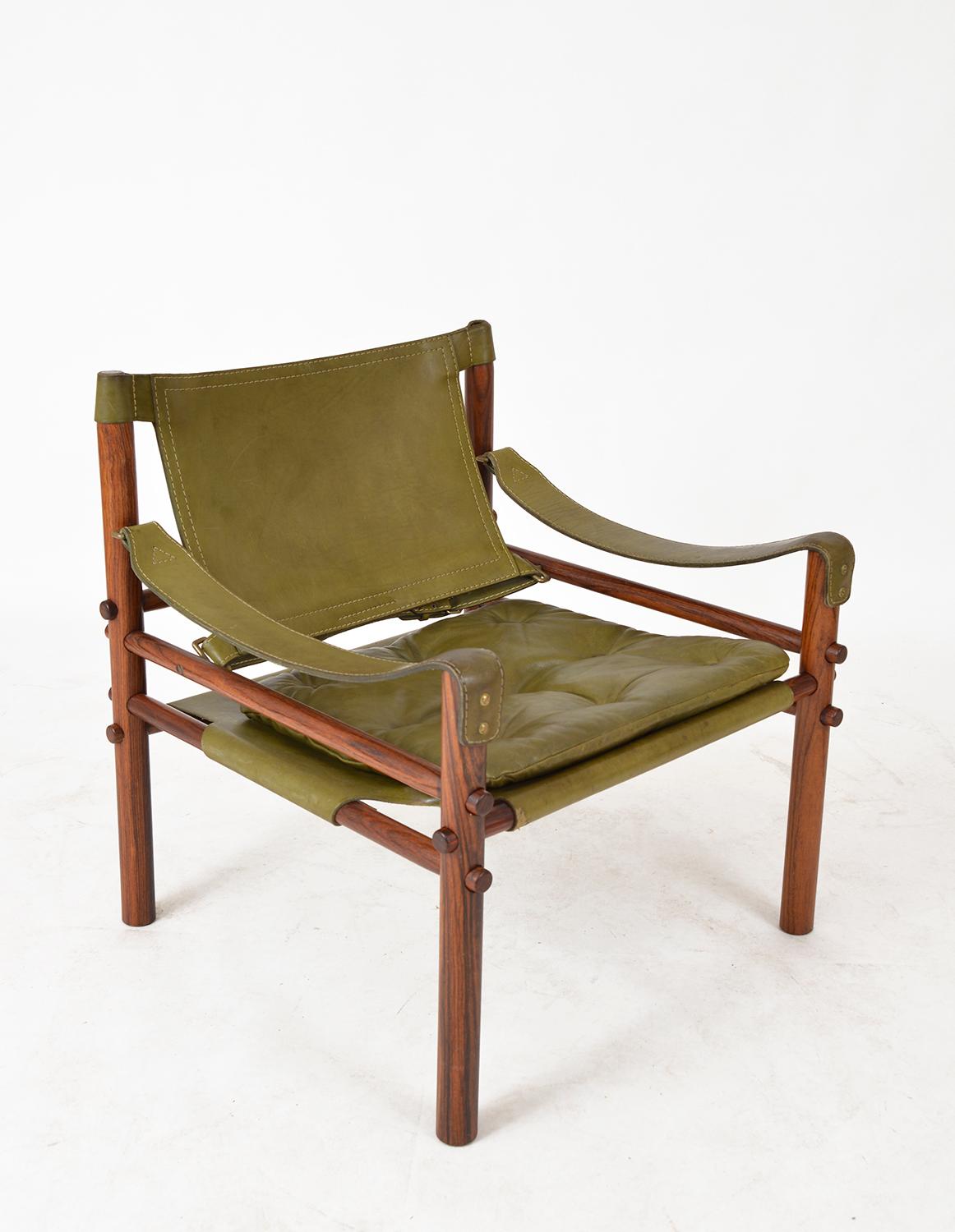 A beautiful example of a 1960s Arne Norell “Sirocco” Safari chair in green leather and rosewood – in my opinion the most stunning of combinations! 
This ingenious chair was designed in 1964 by Arne Norell to completely break down into its component