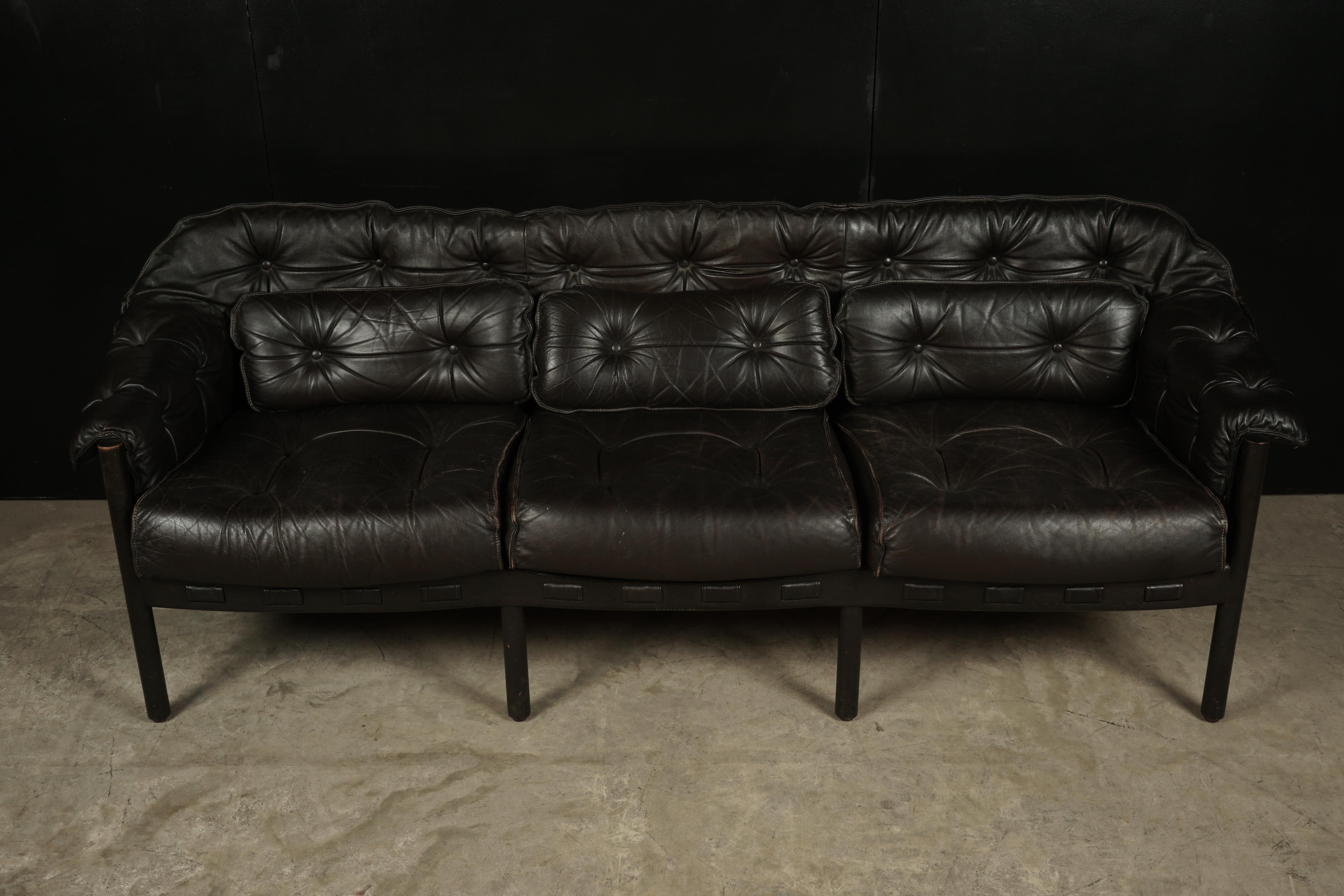 Midcentury Arne Norell sofa from Sweden, circa 1960. Three-seat model in dark brown leather, almost black color. Manufactured by Coja, Sweden.