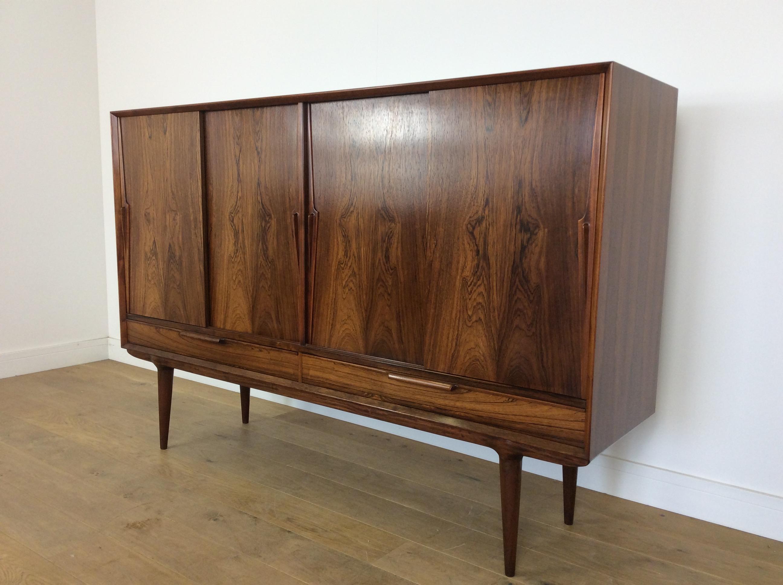 Midcentury rosewood high board cabinet.
Designed in the late 1950s by Arne Vodder and manufactured by Sibast furniture in the 1960s.
Beautiful grain to the rosewood.
Measures: 120.5 cm H, 180 cm W, 46.5 cm D.
Danish, circa 1960.
