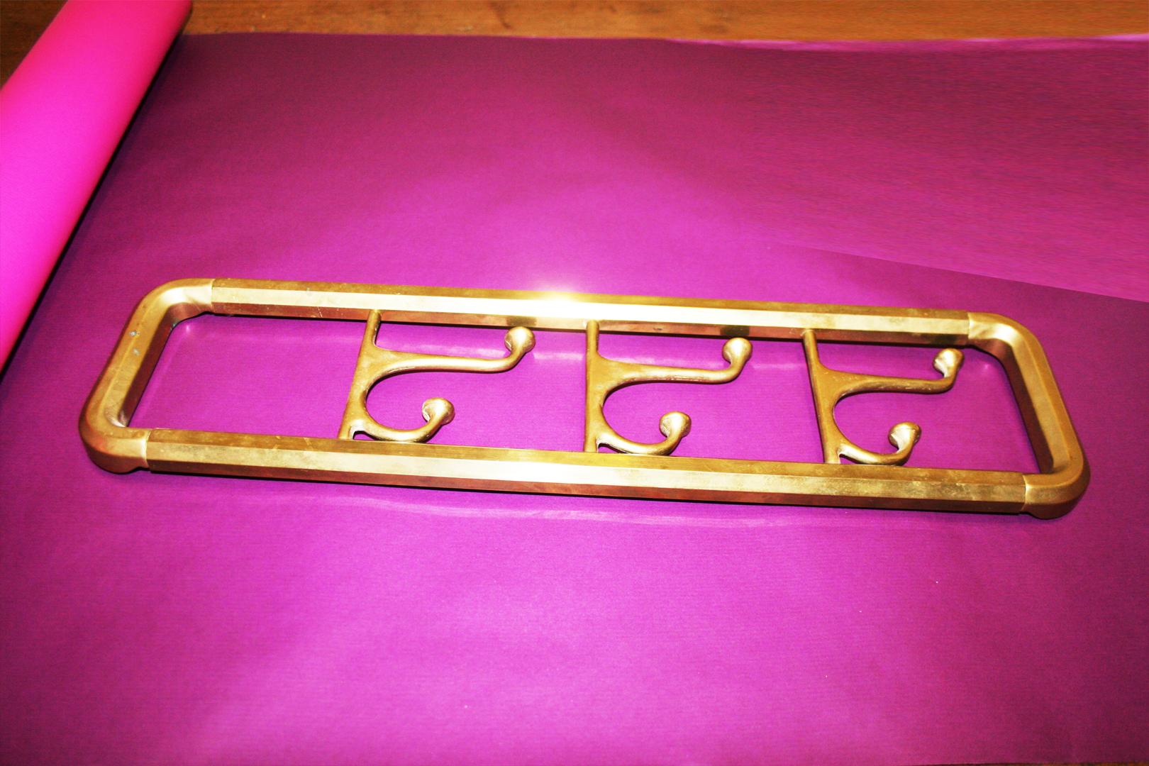 Midcentury / Art Deco foldable wall coat rack in brass

Foldable with three hangers

Very good vintage condition.