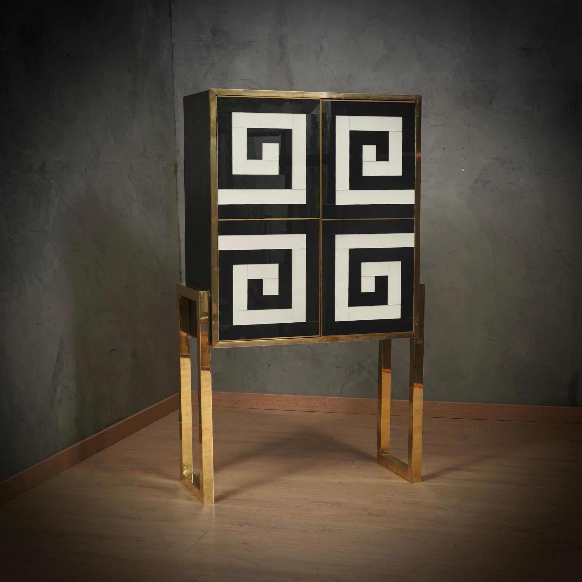 Le meuble est constitué de lignes carrées et décisives, avec l'utilisation de couleurs basiques, comme le blanc et le noir, et l'expressivité de matériaux élégants comme le laiton et le verre artistique, sa force expressive et sa structure