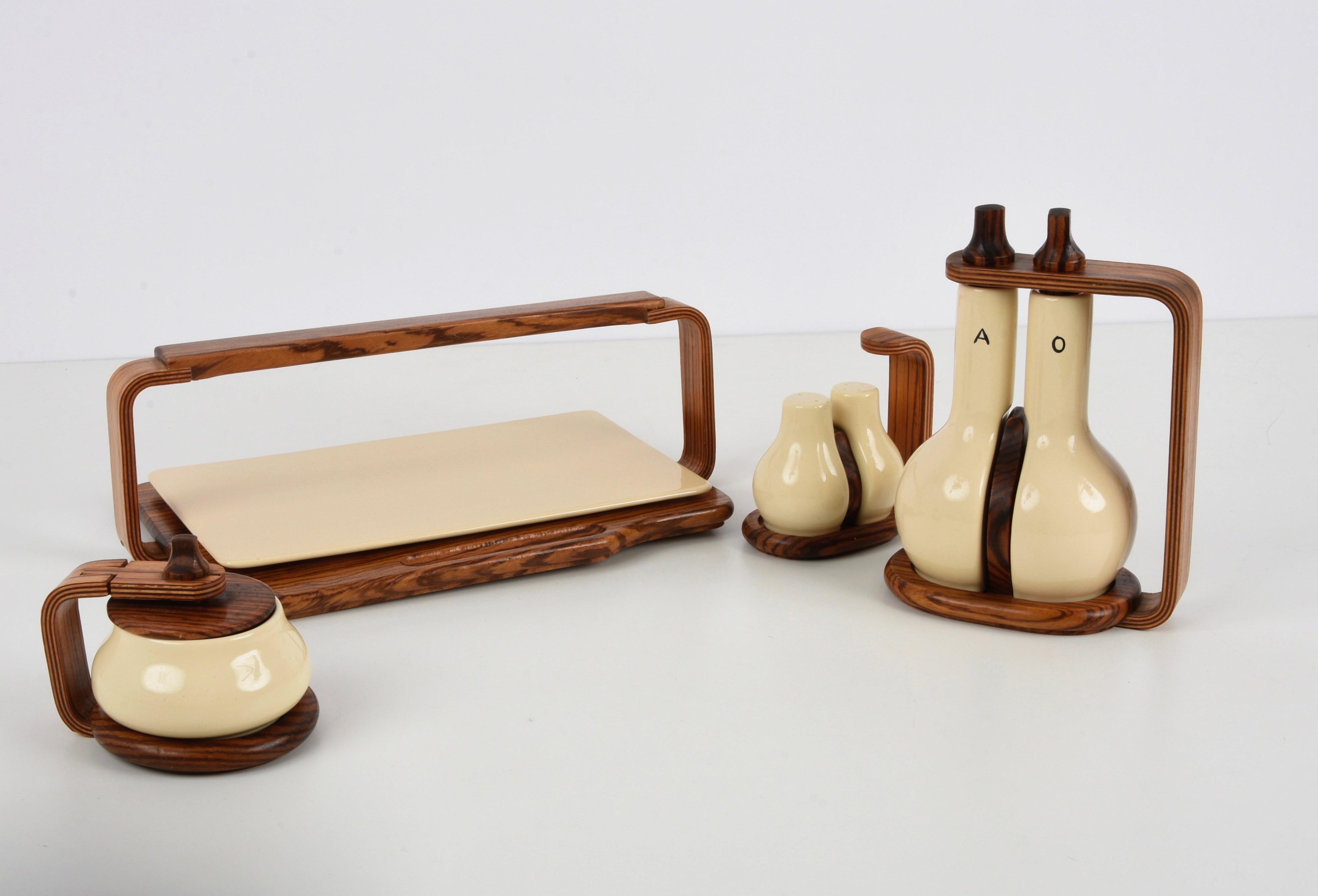 Beautiful midcentury white ceramic and teak tableware. This fantastic piece was designed by Artek in Alvar Aalto style during the 1970s.

An enchanting set, that includes:
a teak and ceramic cheese tray;
a salt and pepper shakers set;
a set of