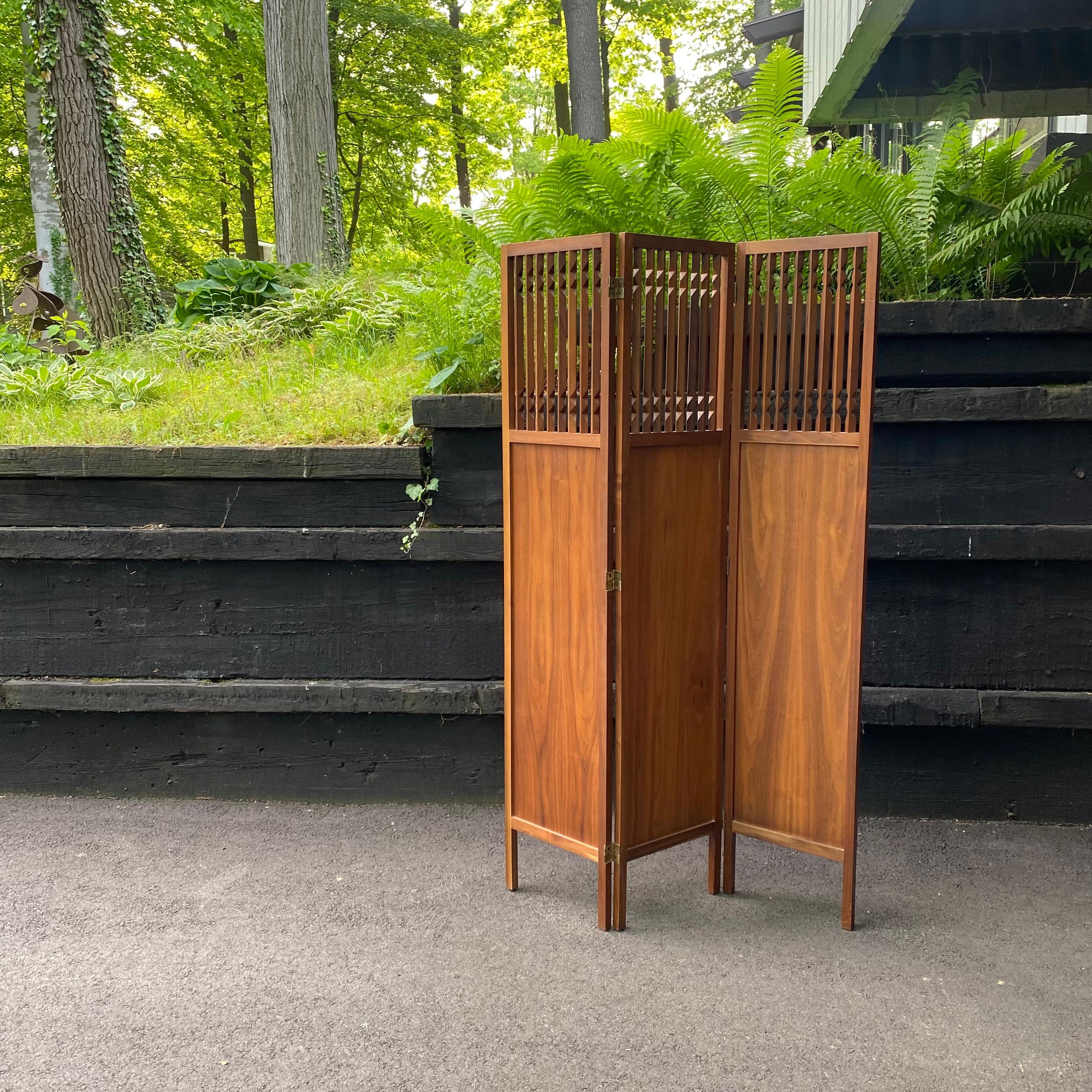 This is a beautiful solid walnut three-panel, double-sided screen designed by Arthur Umanoff for Washington Woodcraft, ca. 1964. It works on a double-hinge mechanism so it can be manipulated to fit many spaces. When you don't want to use it, simply