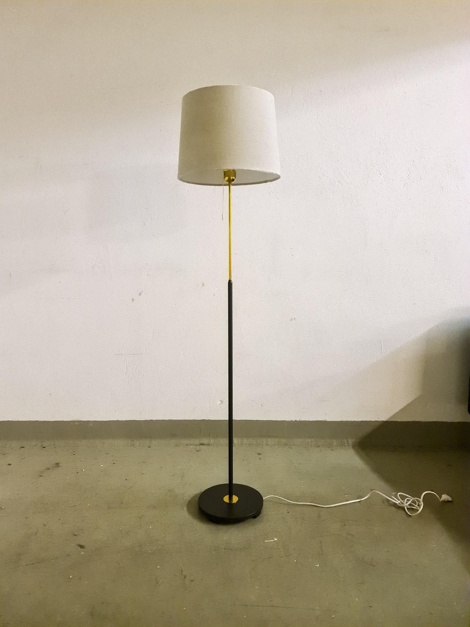 A gorgeous floor lamp made in brass and black hardened plastic. Produced for ASEA this wonderful lamp was most likely designed by Hans Bergström.

Good working condition. The shade in velvet is not original it’s a new and comes with the purchase