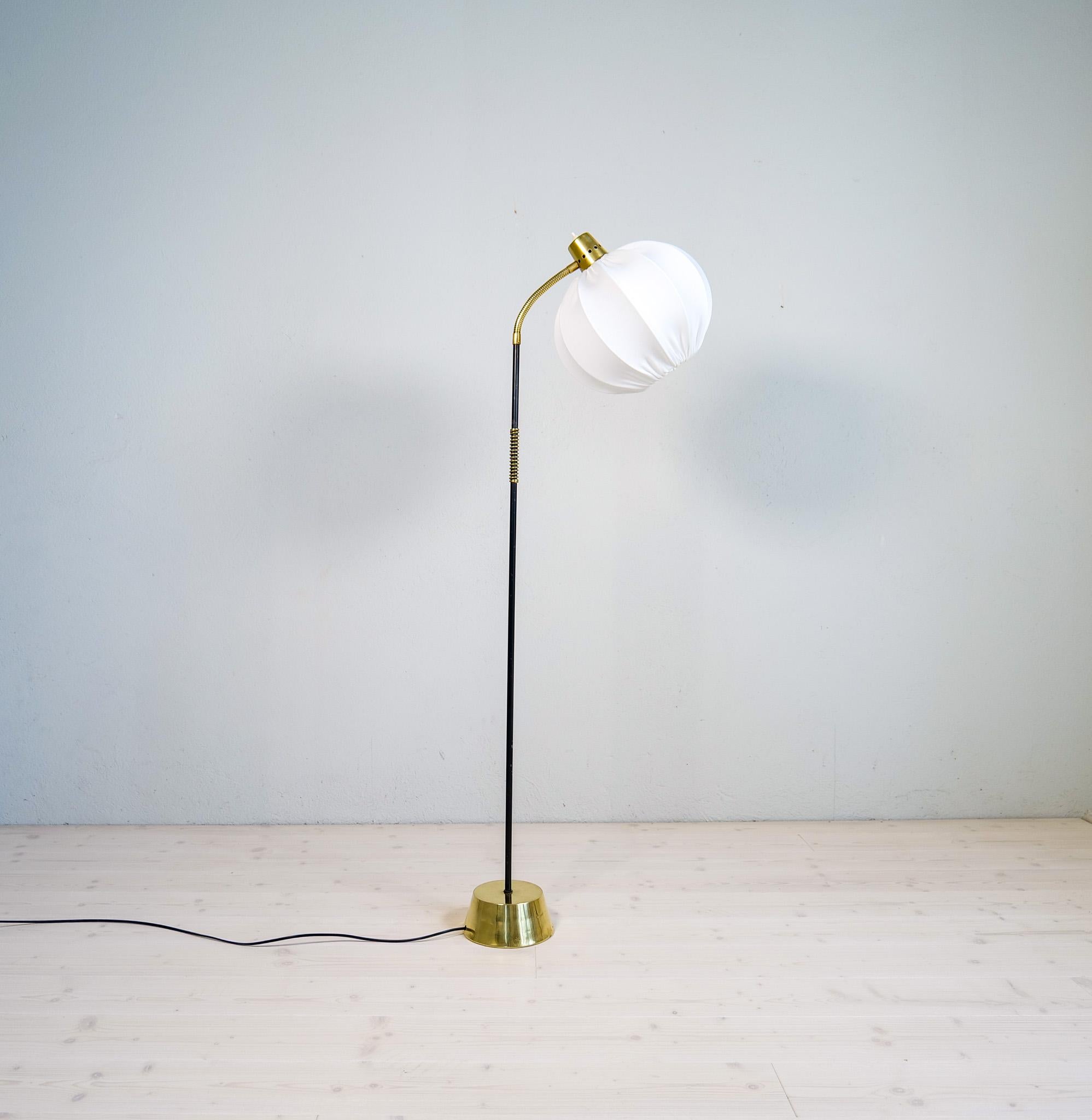 A gorgeous floor lamp made in brass and metal with a rounded cotton shade. Produced for ASEA this wonderful lamp was most likely designed by Hans Bergström.

Good working condition with losses to the paint on the rod. The shade made in cotton is