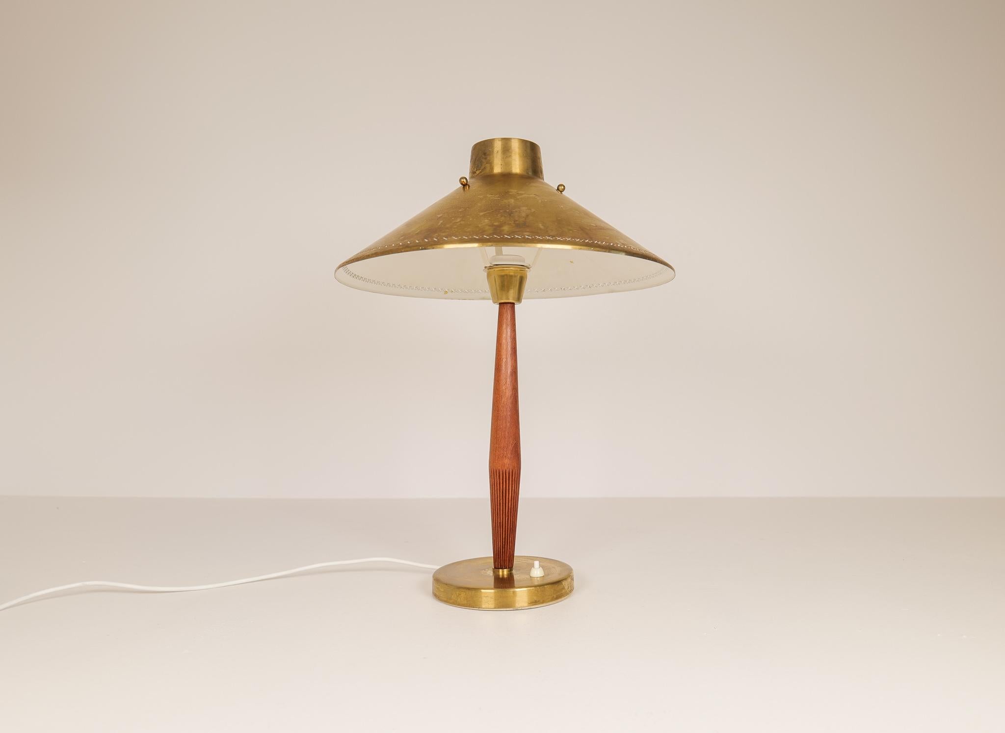 Elegant Swedish table lamp made in 1940 for ASEA and designed by Hans Bergström. A metal and brass base with teak leading up to a patinated brass shade in a nice combination. 

Good condition with some wear consistent with age and