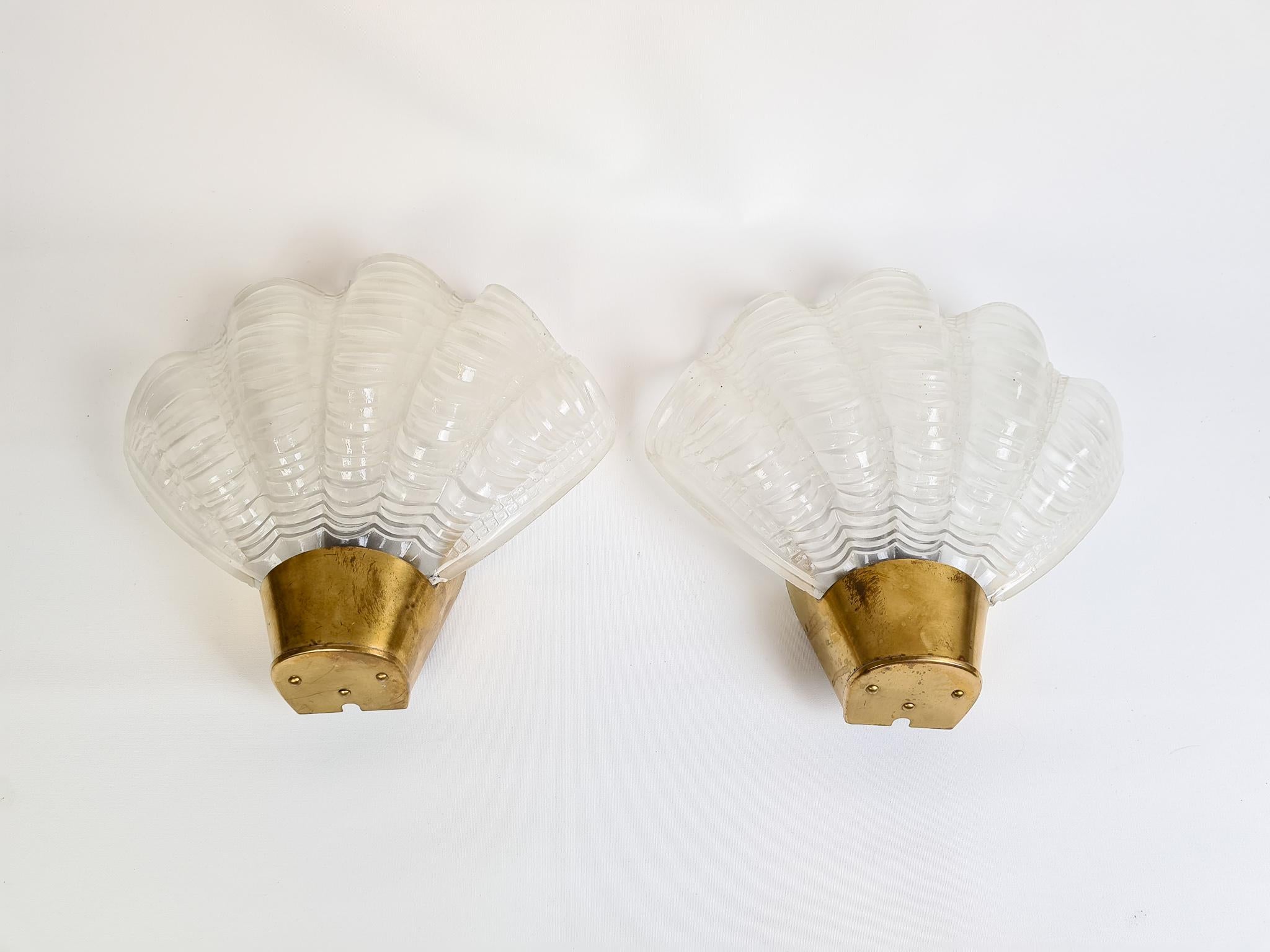 This set of 2 wall lights in brass and glass was produced by ASEA, Sweden, 1950s.

Good vintage condition, small chips on the bottom of the glass. 

New wiring available on request.

Measures: Height 8.67 in. (22 cm), width 9.85 in. (25 cm),