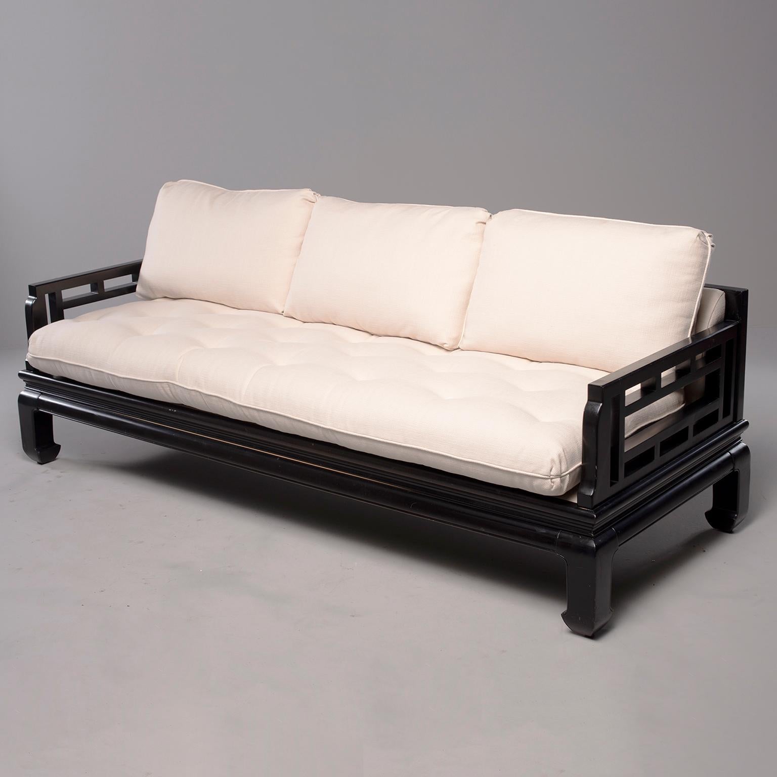 Asian James Mont style sofa has a black wooden frame with open work design in the back and at the sides and chow style legs, circa 1970s. Measures: Arms are 24